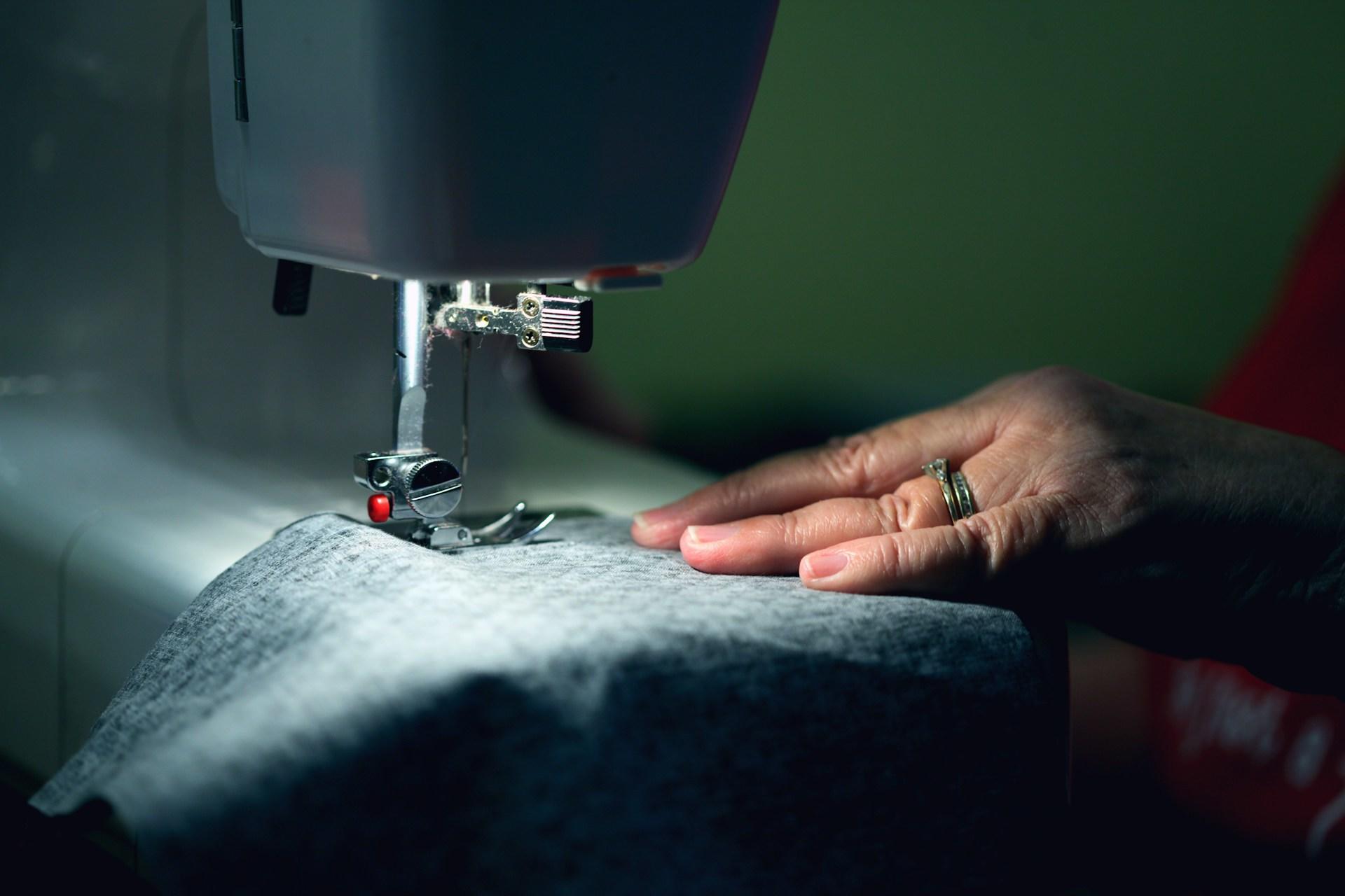 Nähmaschine mit Stoff von Hand bedient.