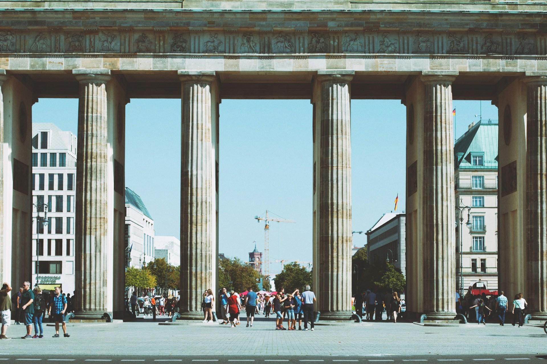 Menschen unter Gebäude mit Säulen.