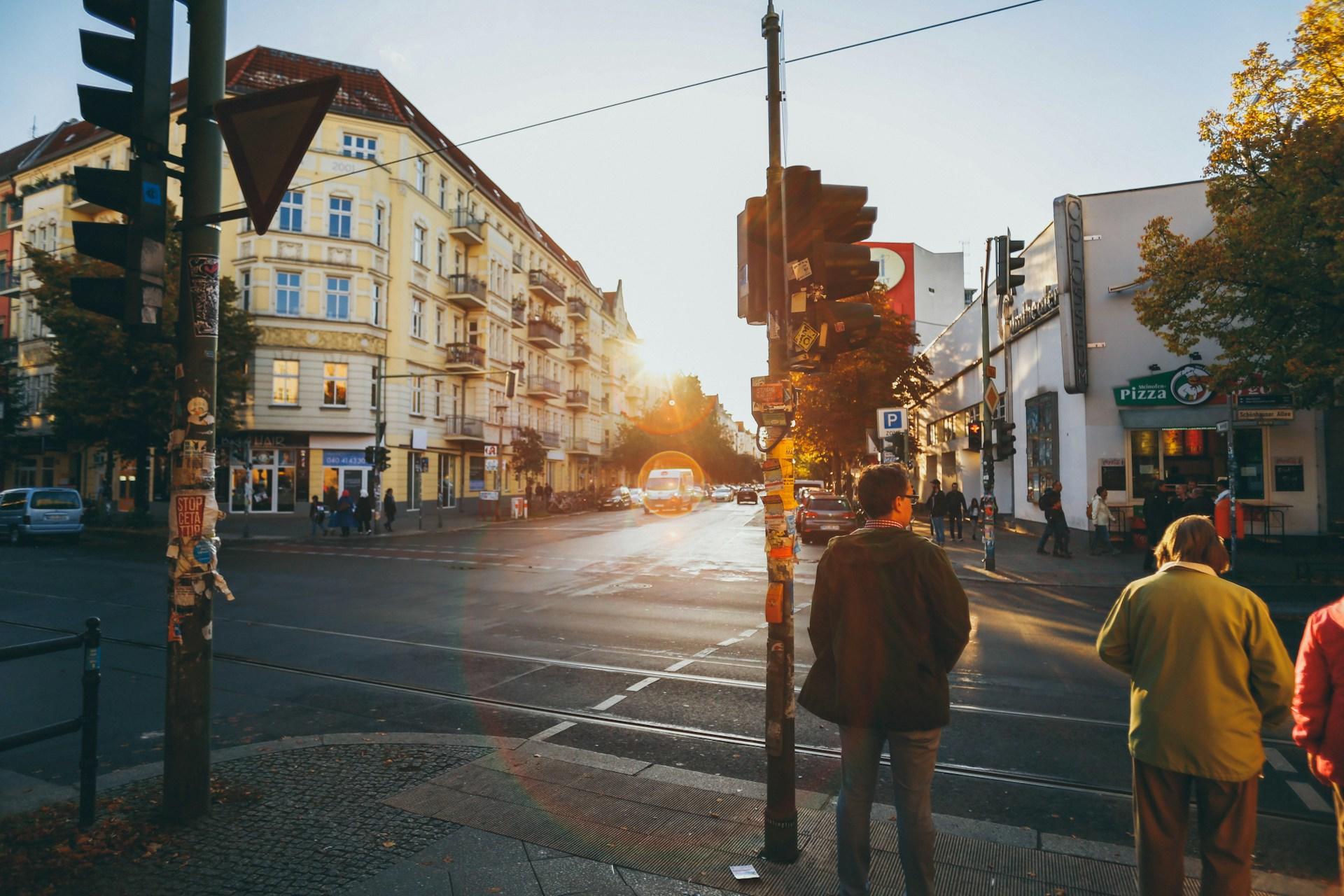 Straßenecke mit Menschen an der Ampel.