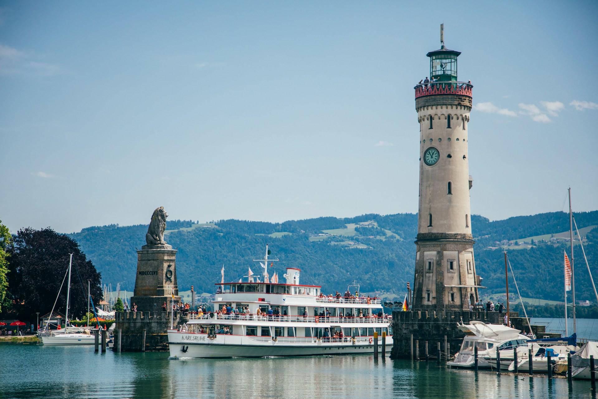 Fähre auf See neben Leuchtturm.