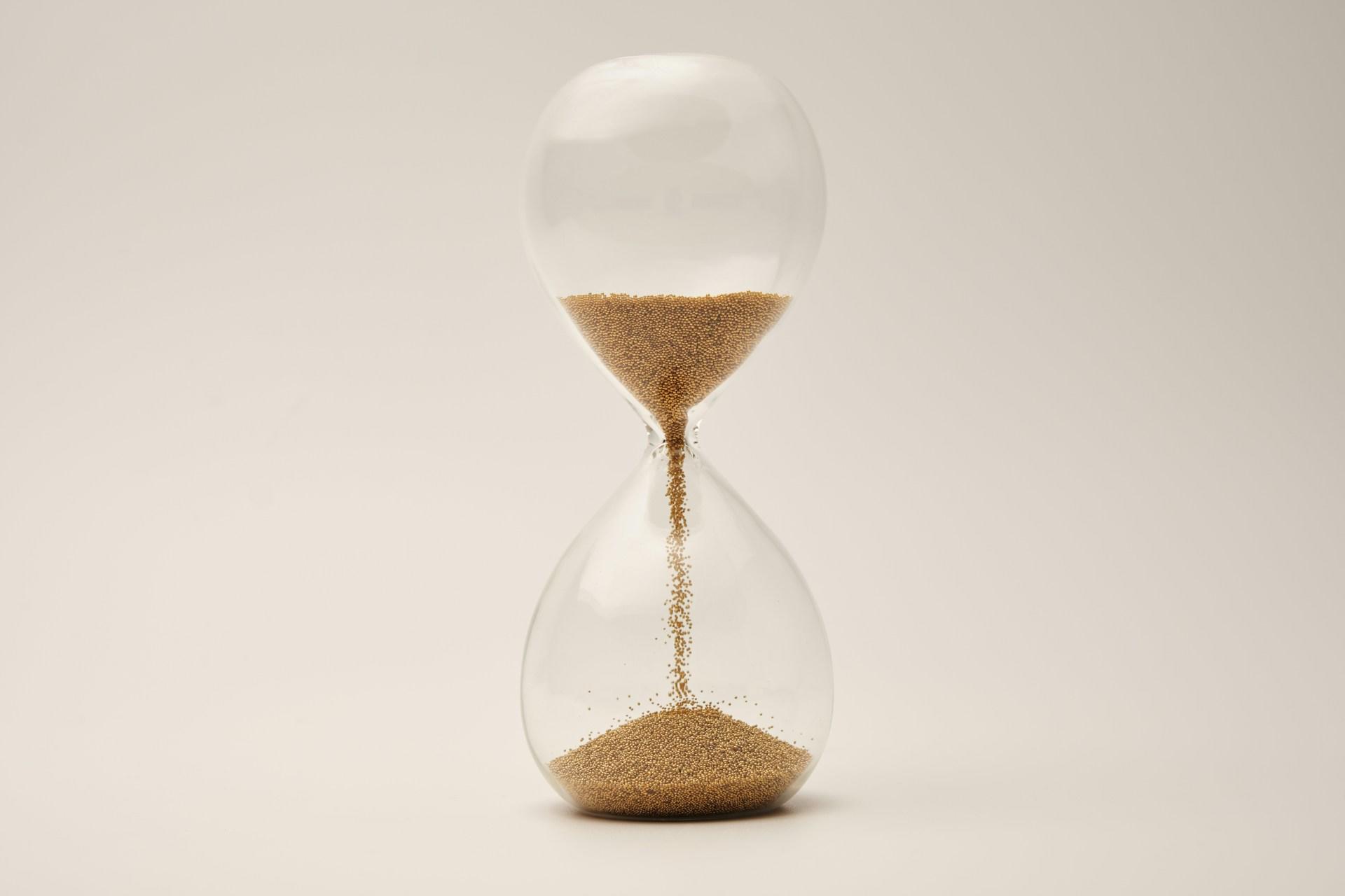 In einer Sanduhr rieselt Sand von einem Glas ins andere.