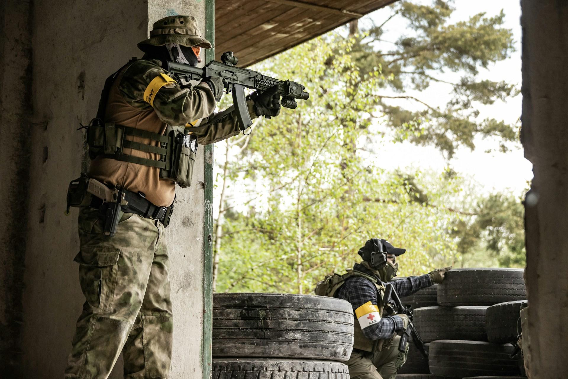 Zwei Soldaten stehen schussbereit in einer Baracke.