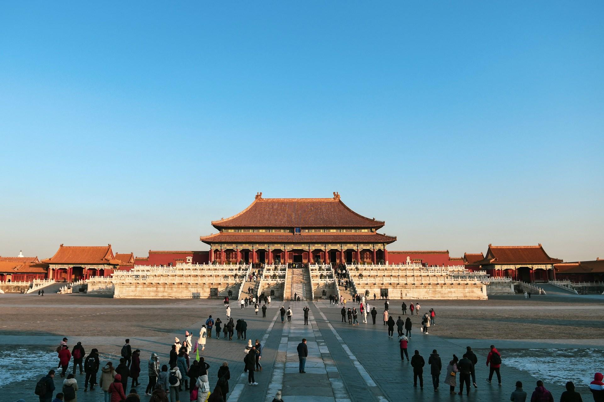 Menschen auf einem Platz vor einem chinesischen Tempel