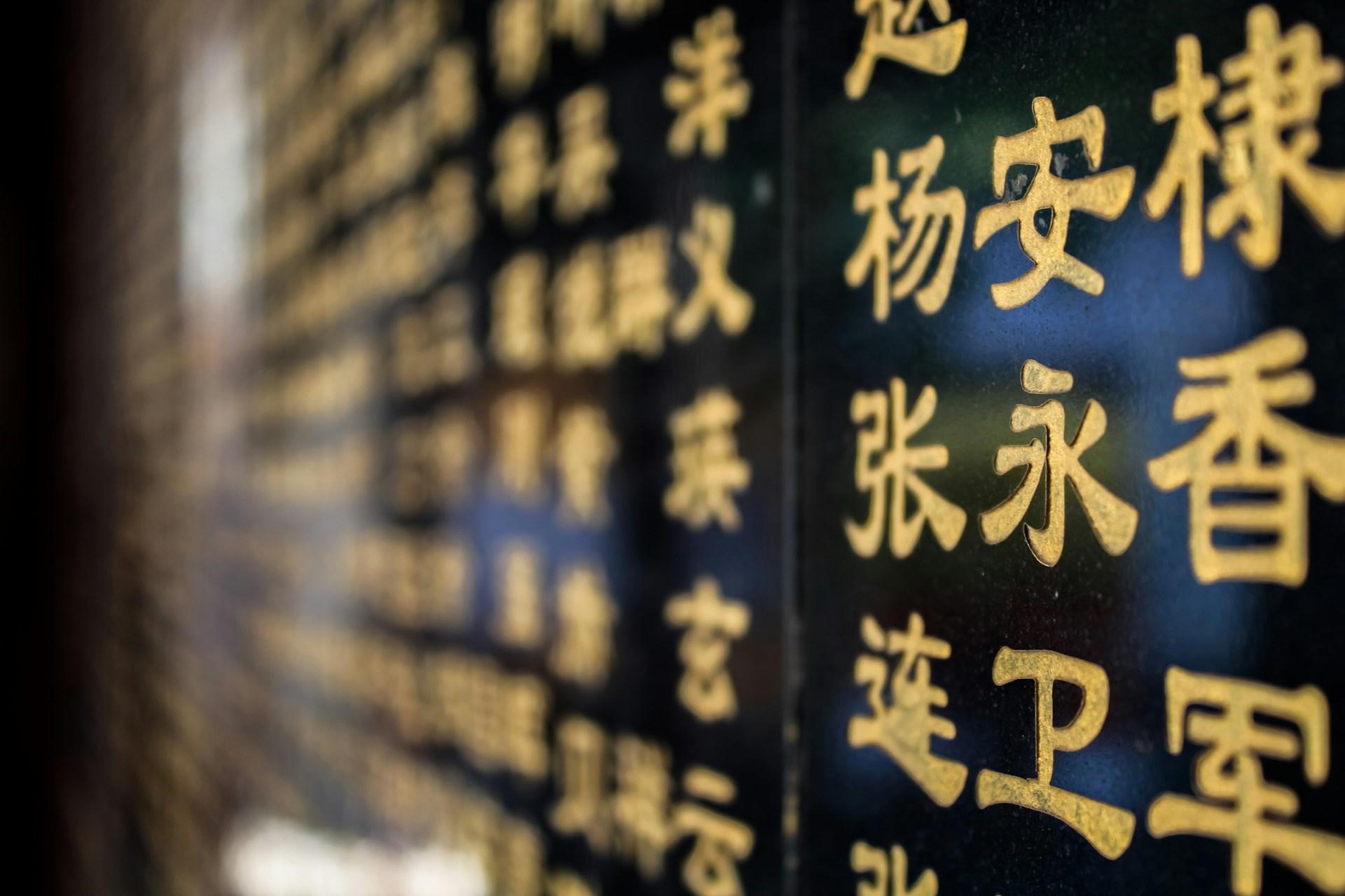 Schwarze Wand mit gelben chinesischen Schriftzeichen.