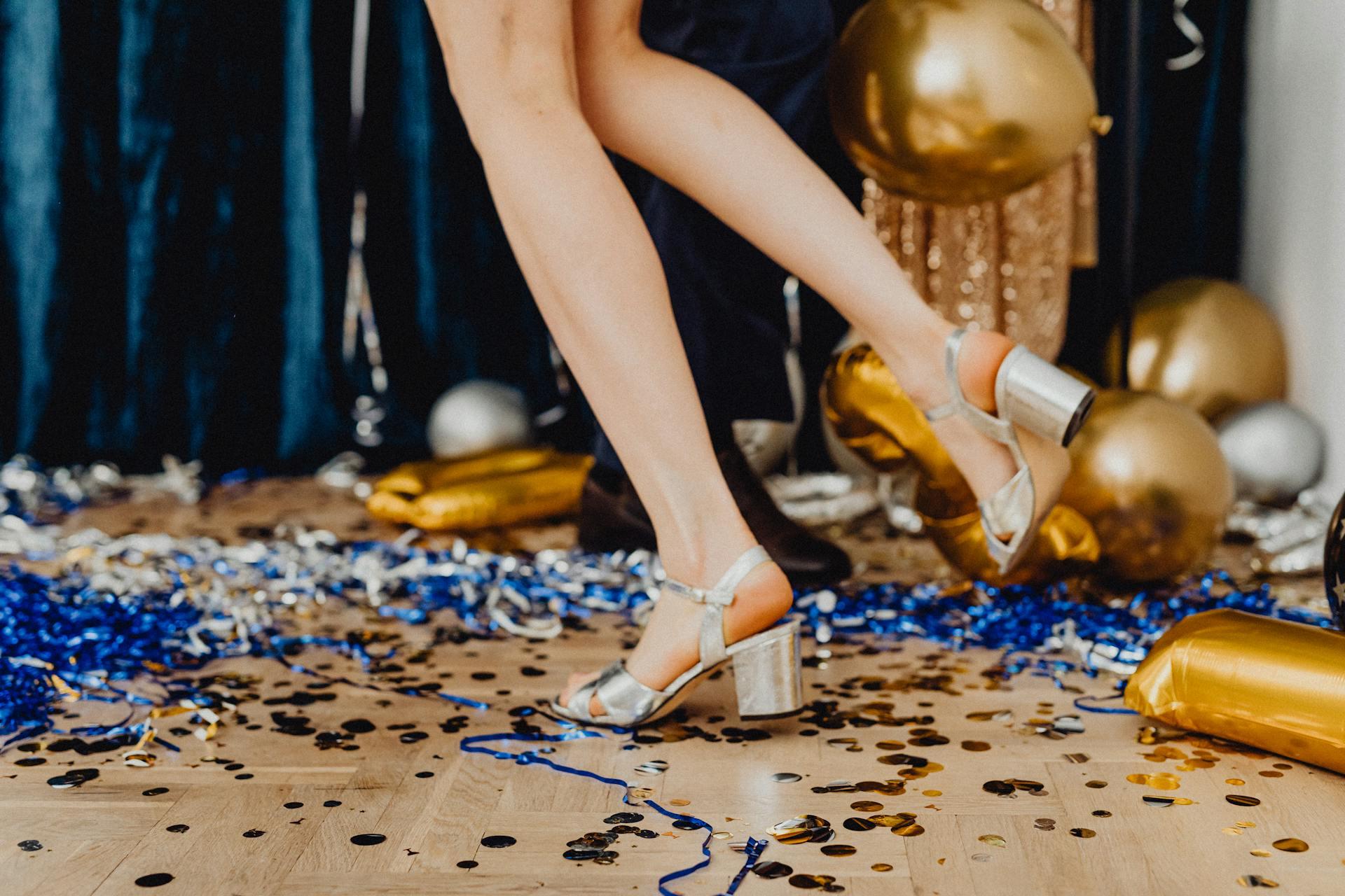 Goldene Luftballons auf dem Boden mit blauem Konfetti
