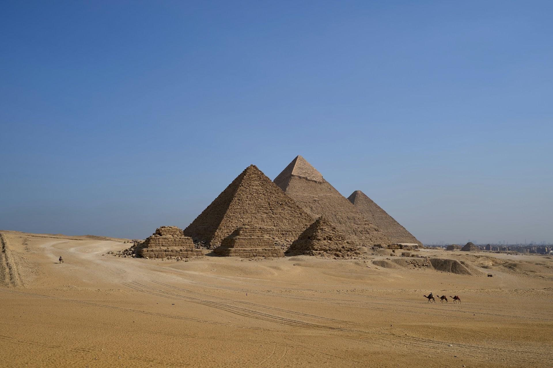 Die Pyramiden von Gizeh in der Wüte vor blauem Himmel