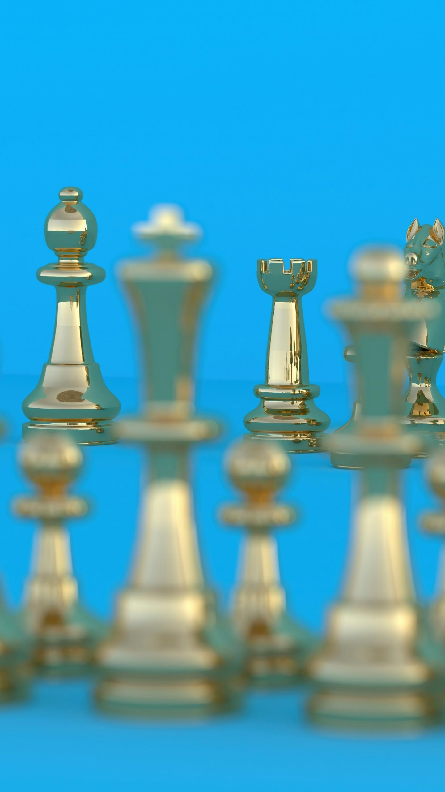 Goldene Schachfiguren vor blauem Hintergrund