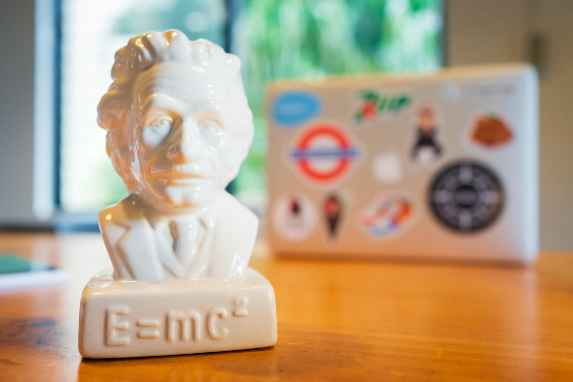 Statue von Albert Einstein auf Schreibtisch vor Laptop.