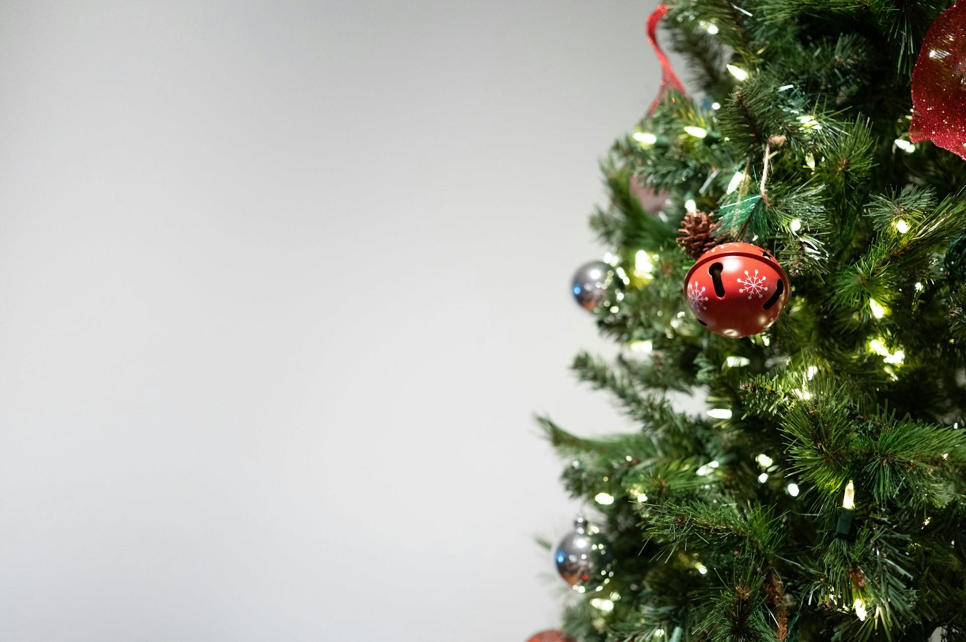 Nahaufnahme eines Weihnachtsbaums mit Kugeln und einer Lichterkette