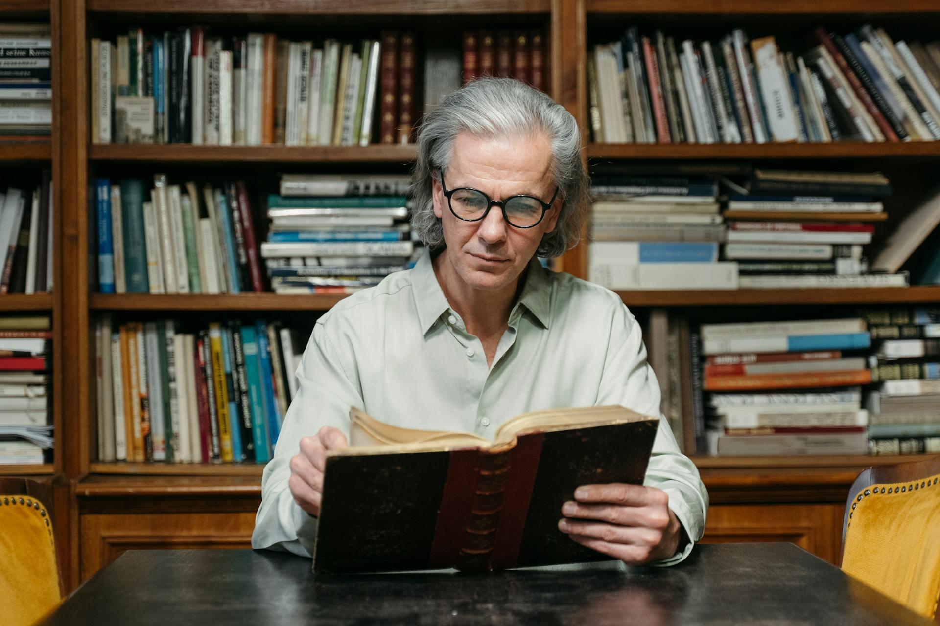 Professor liest ein Buch in einer Bibliothek