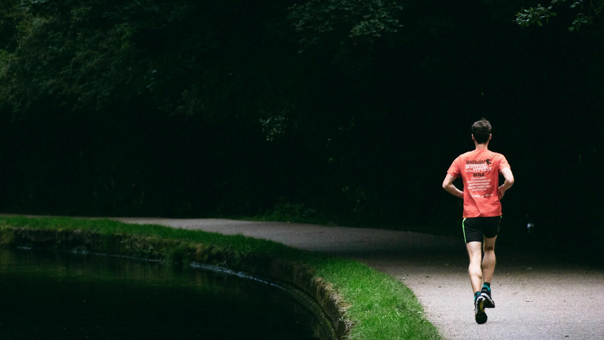 Person joggt am Ufer eines Gewässers