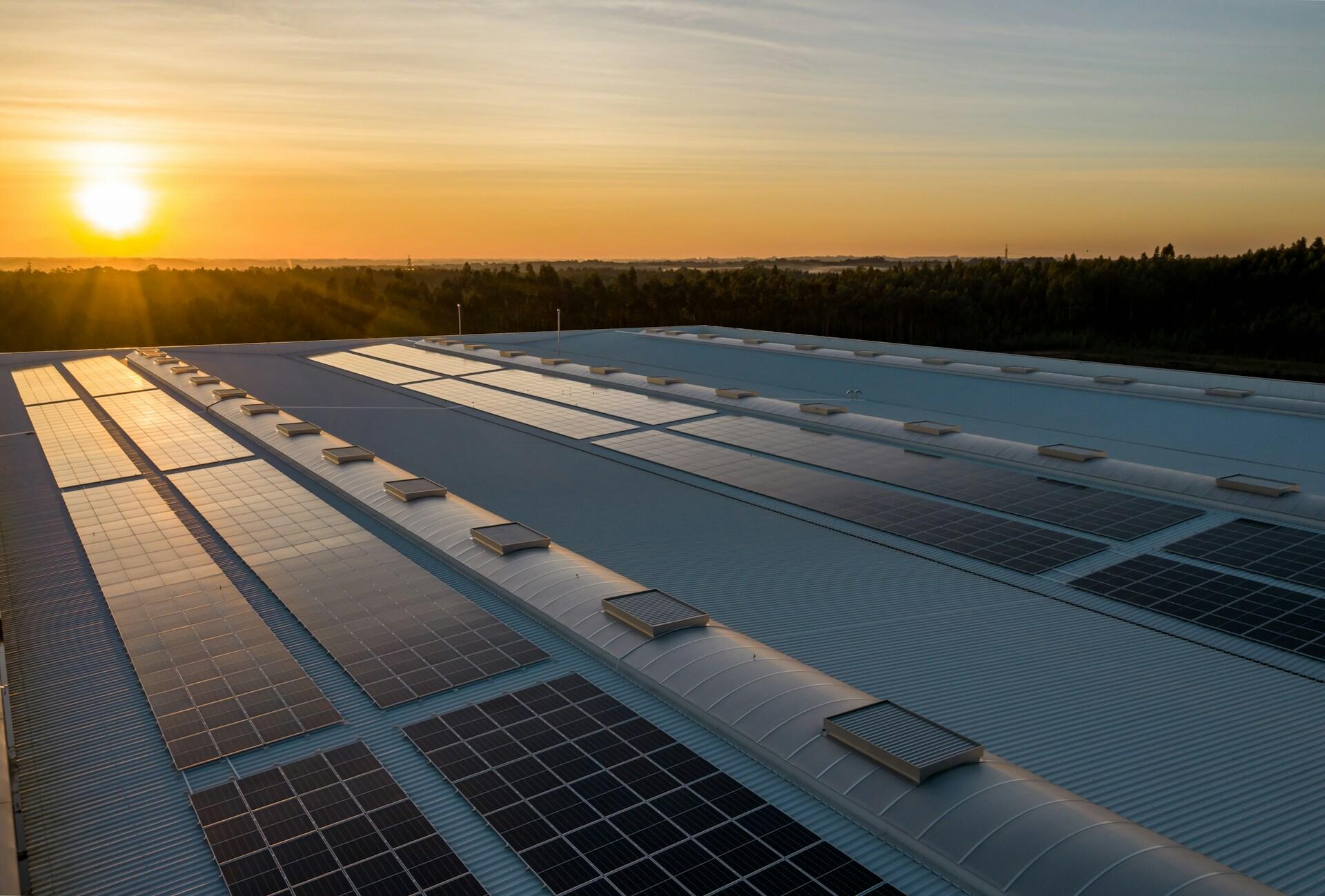 Eine Solaranlage auf einem Dach im Sonnenaufgang.