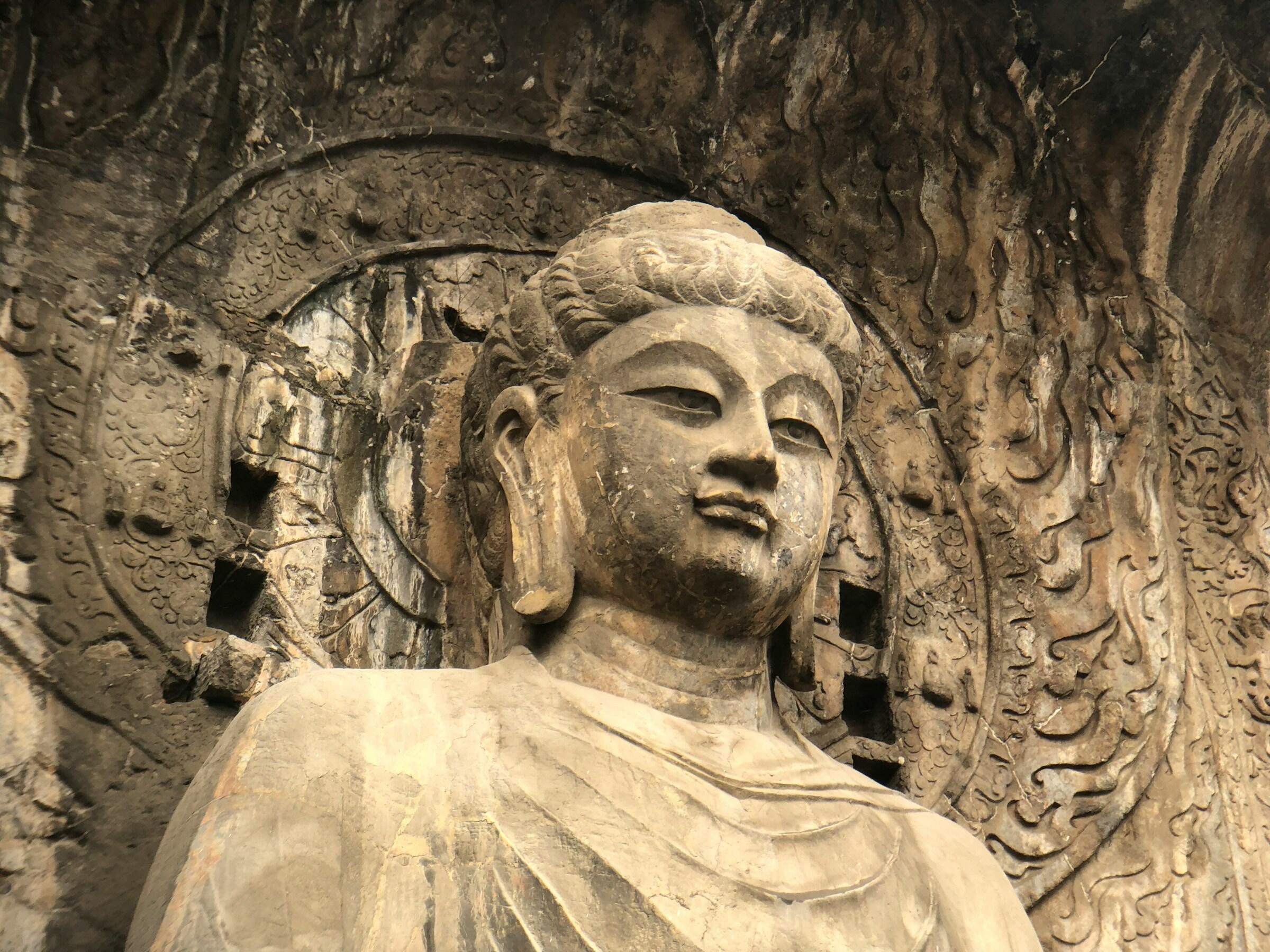 Das Gesicht einer großen Buddha-Statue aus Stein.