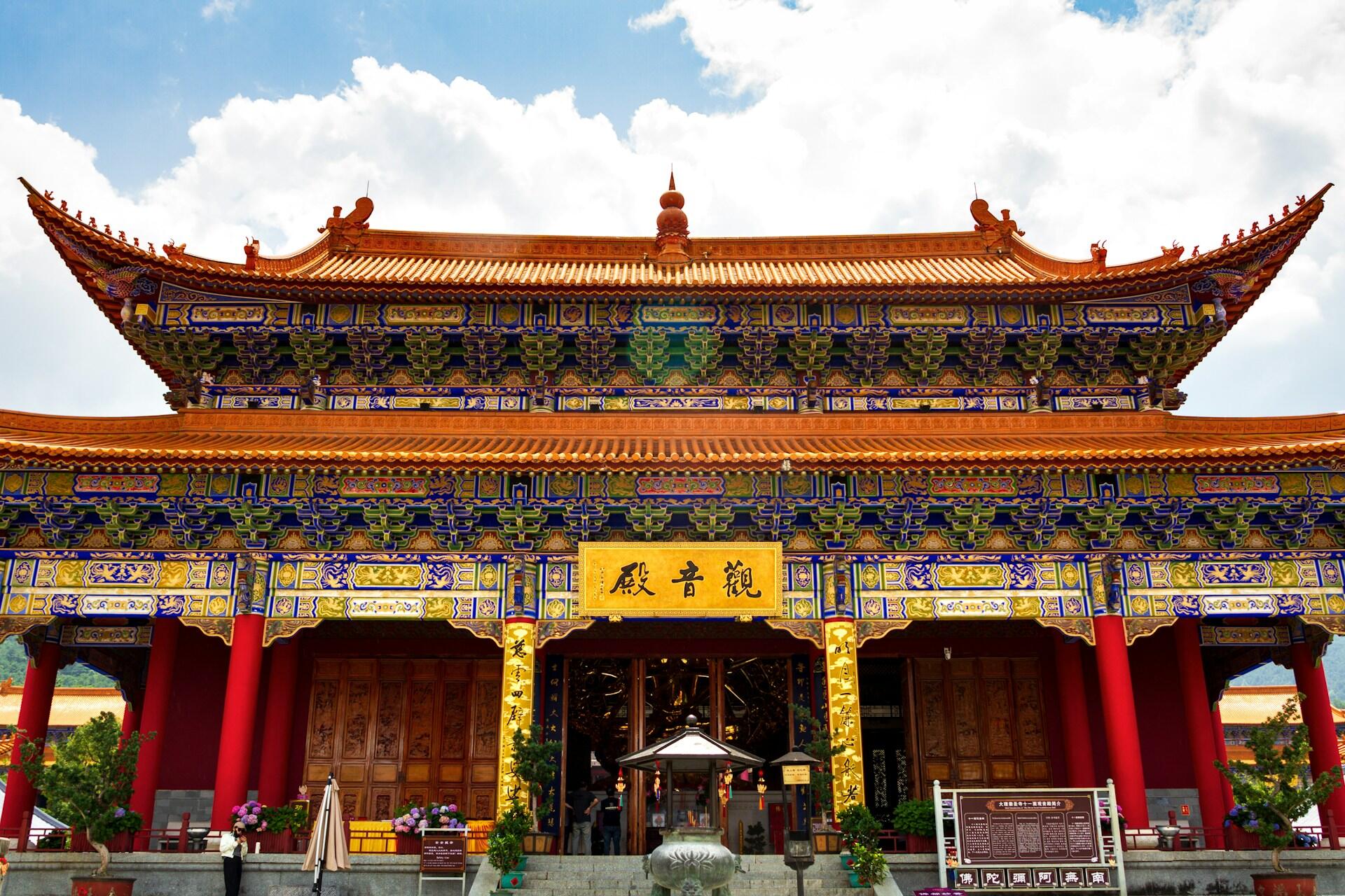 Ein buddhistischer Tempel in China. Er ist bunt gestaltet mit roten, gelben, blauen und grünen Elementen.