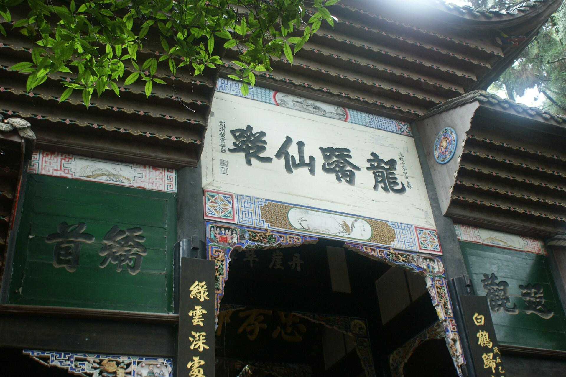 Eine Nahaufnahme von einem taoistischen Tempel. Man sieht einen Teil vom Eingang mit chinesischen Schriftzeichen.