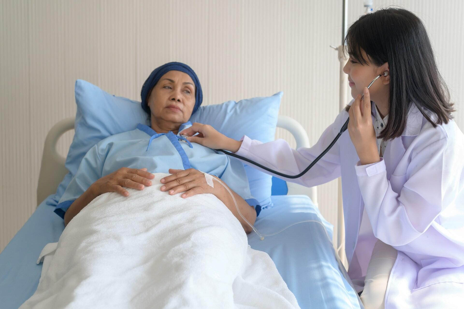 Eine Pflegekraft untersucht eine Person im Krankenhausbett