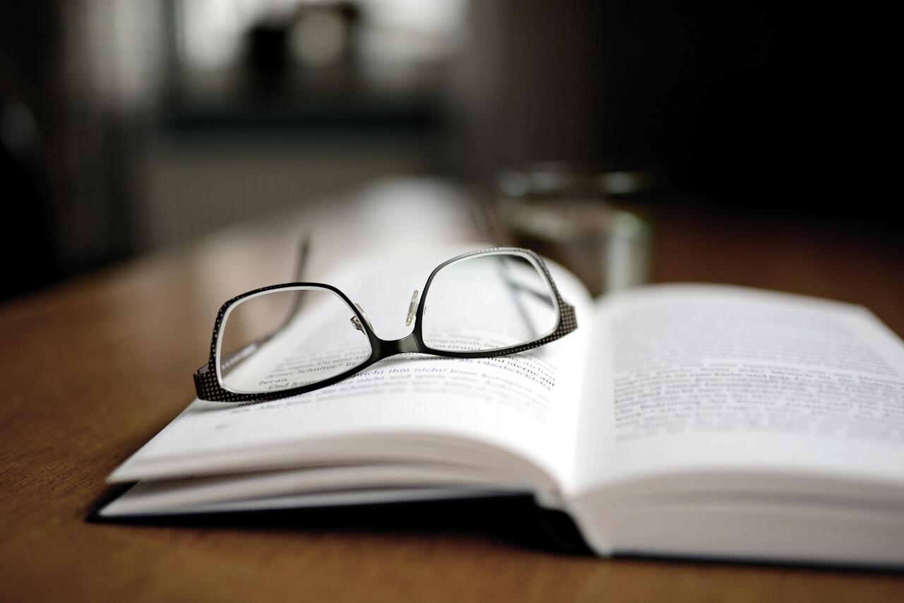 Latein Lehrbuch mit Brille darauf