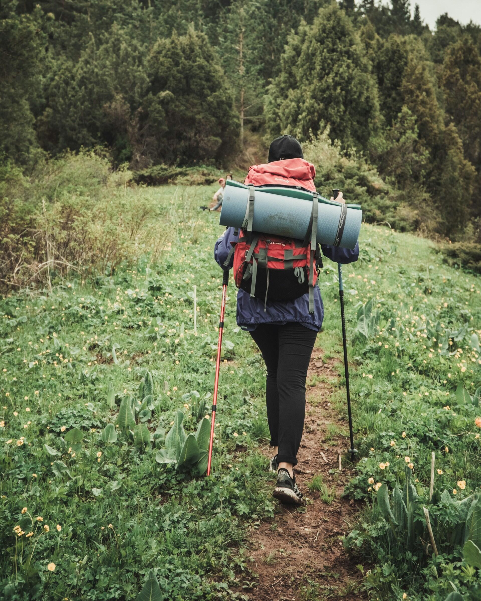 Frau beim Trailrunning mit Stoecken