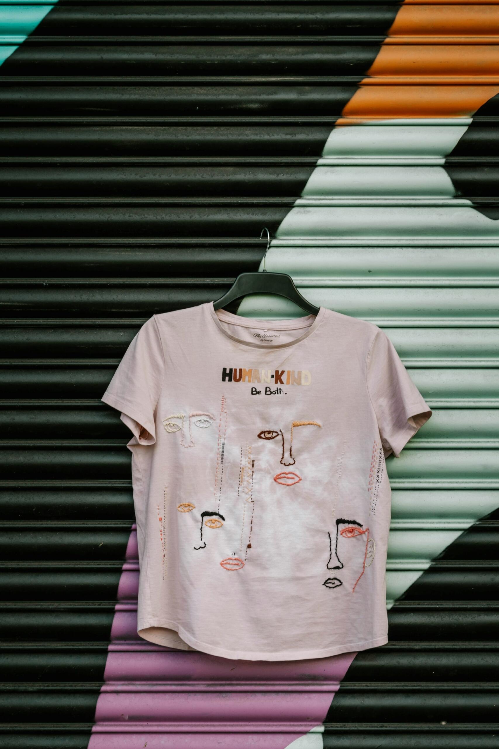 Ein T-Shirt bedruckt mit verschiedenen abstrakten Gesichtern.