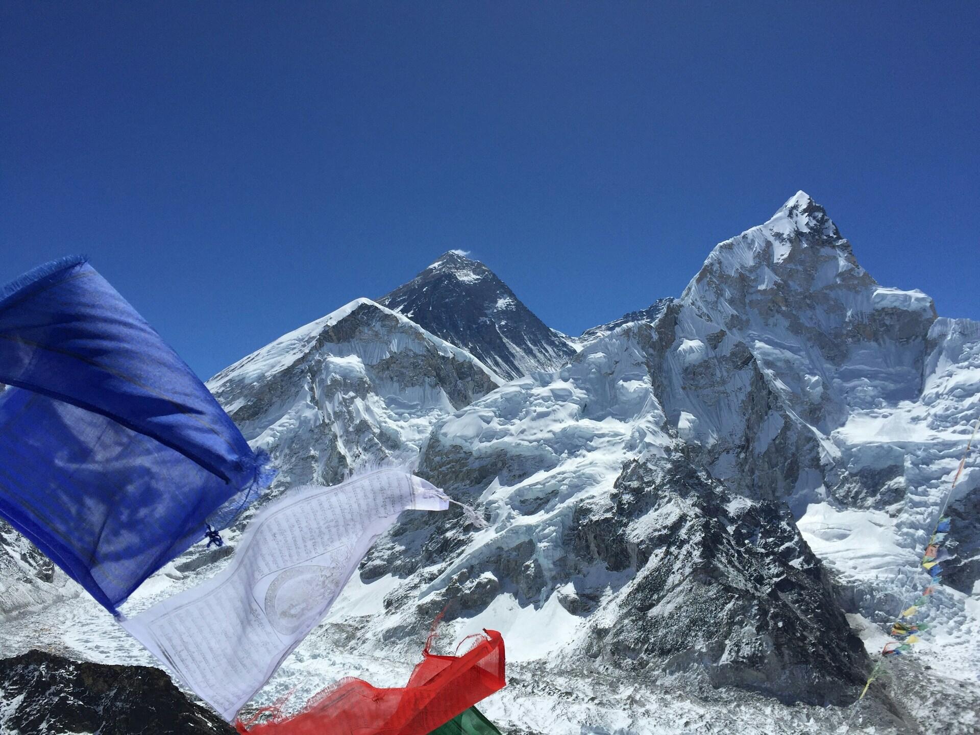 Eine Aufnahme vom Gipfel des Mount Everest vor blauem Himmel.