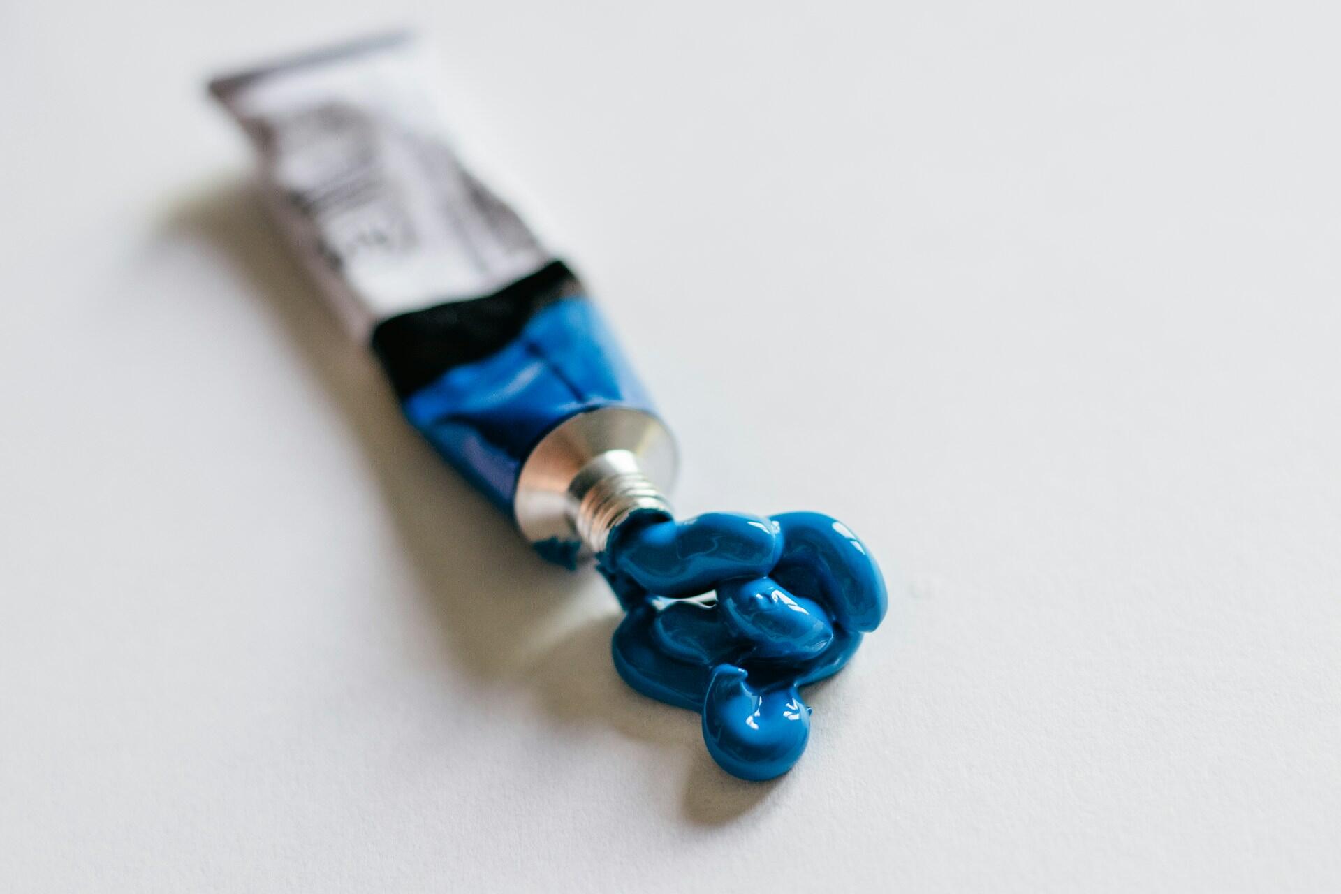 Eine FArbtube, aus der blaue Farbe gequetscht wurde.