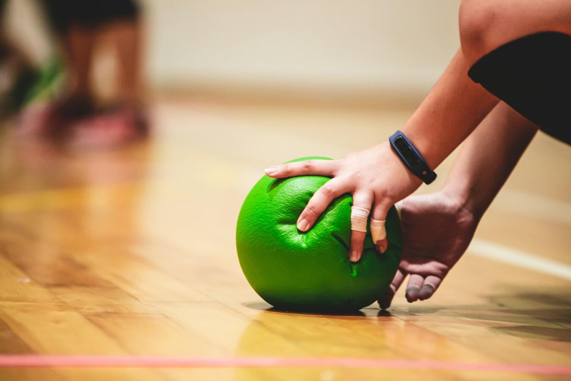 Hand, die den Ball im Brennball-Spiel hält