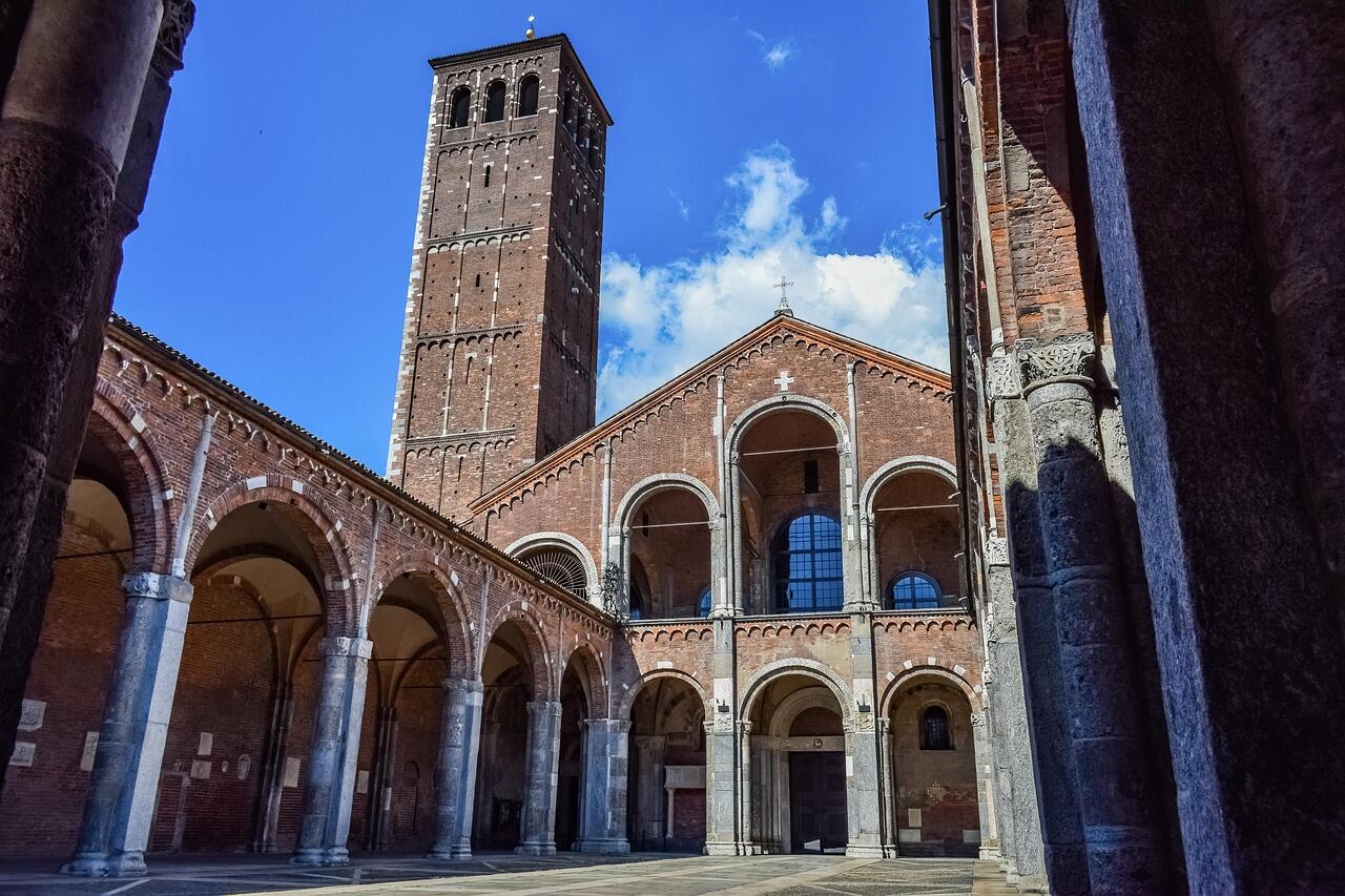 Die Basilica Sant´Ambrogio mit hohem Glockenturm und steinernen Arkaden