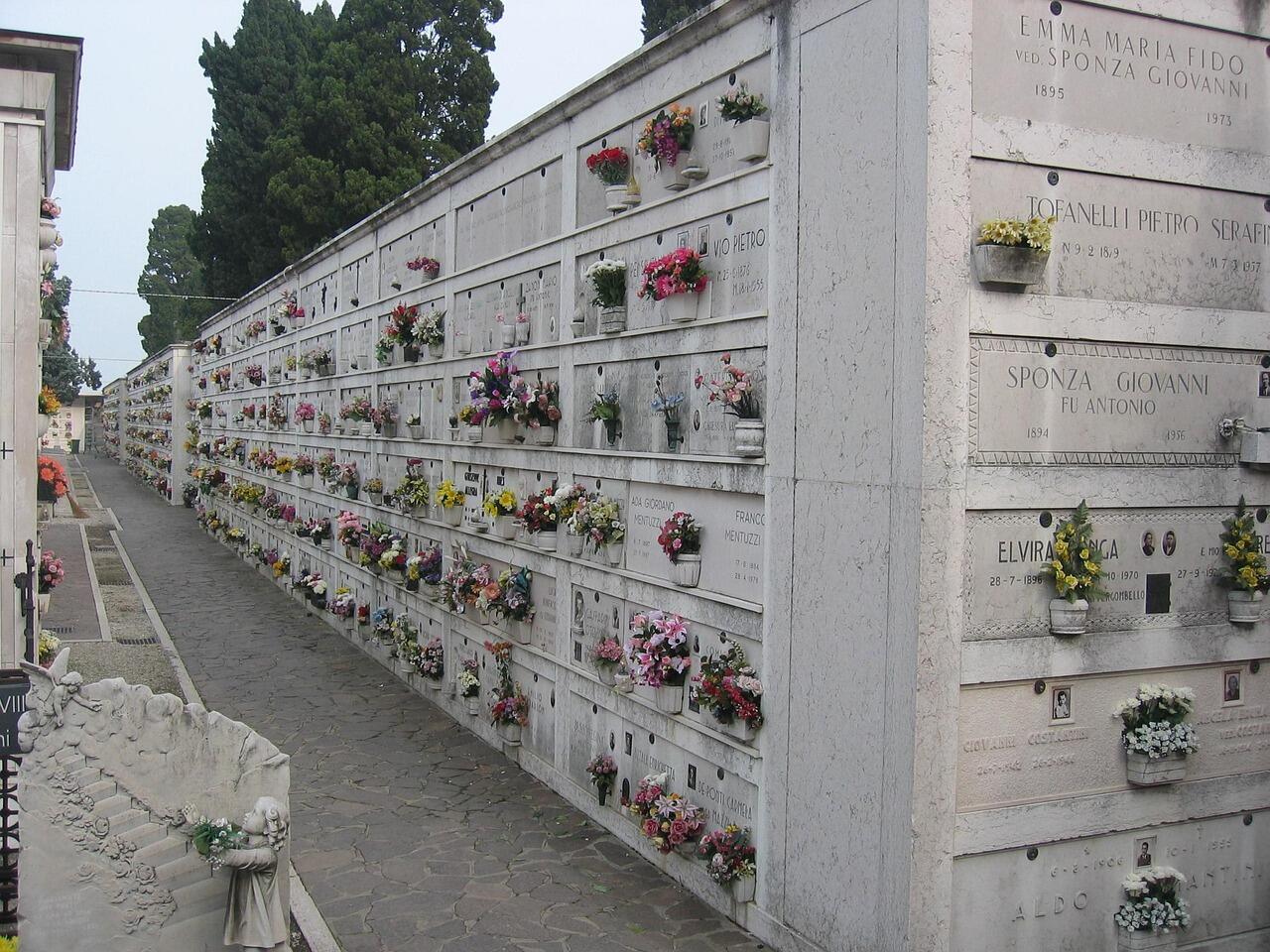Lange Reihe von Urnengräbern mit Blumen