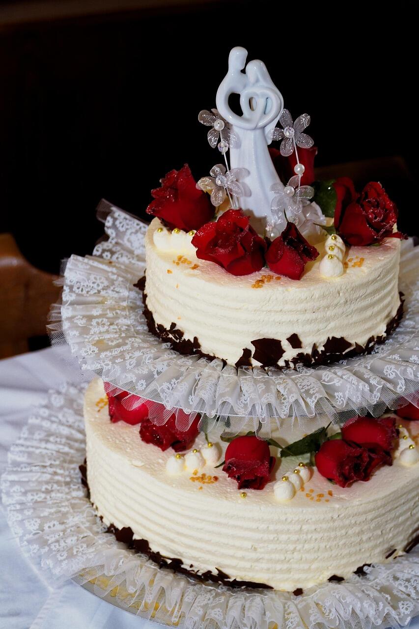 Mehrstöckige Torte mit roten Früchten und der Figur von einem Hochzeitspaar