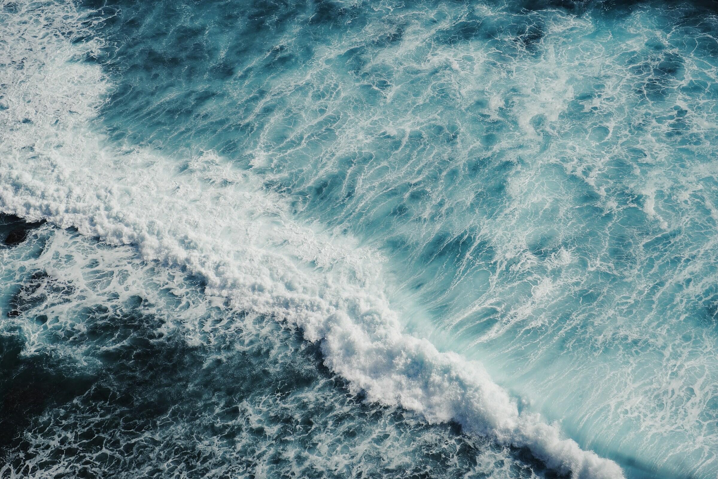 Eine Welle und Gischt auf dem Ozean.