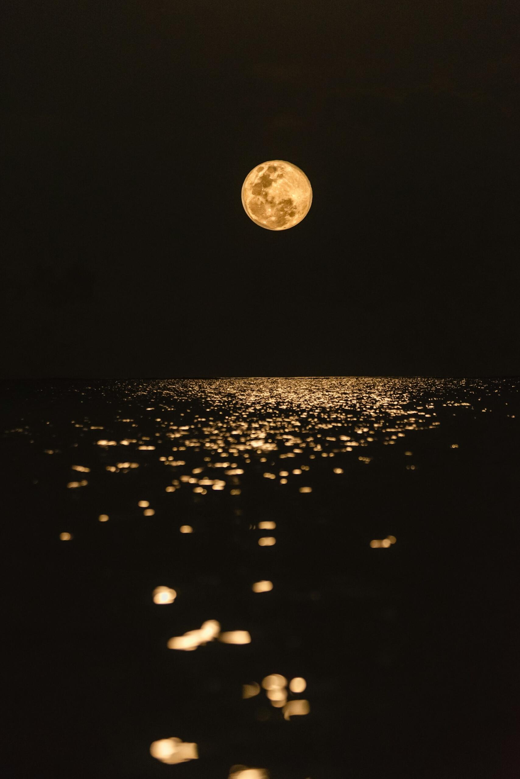 Der Mond leuchtet über dem Meer.