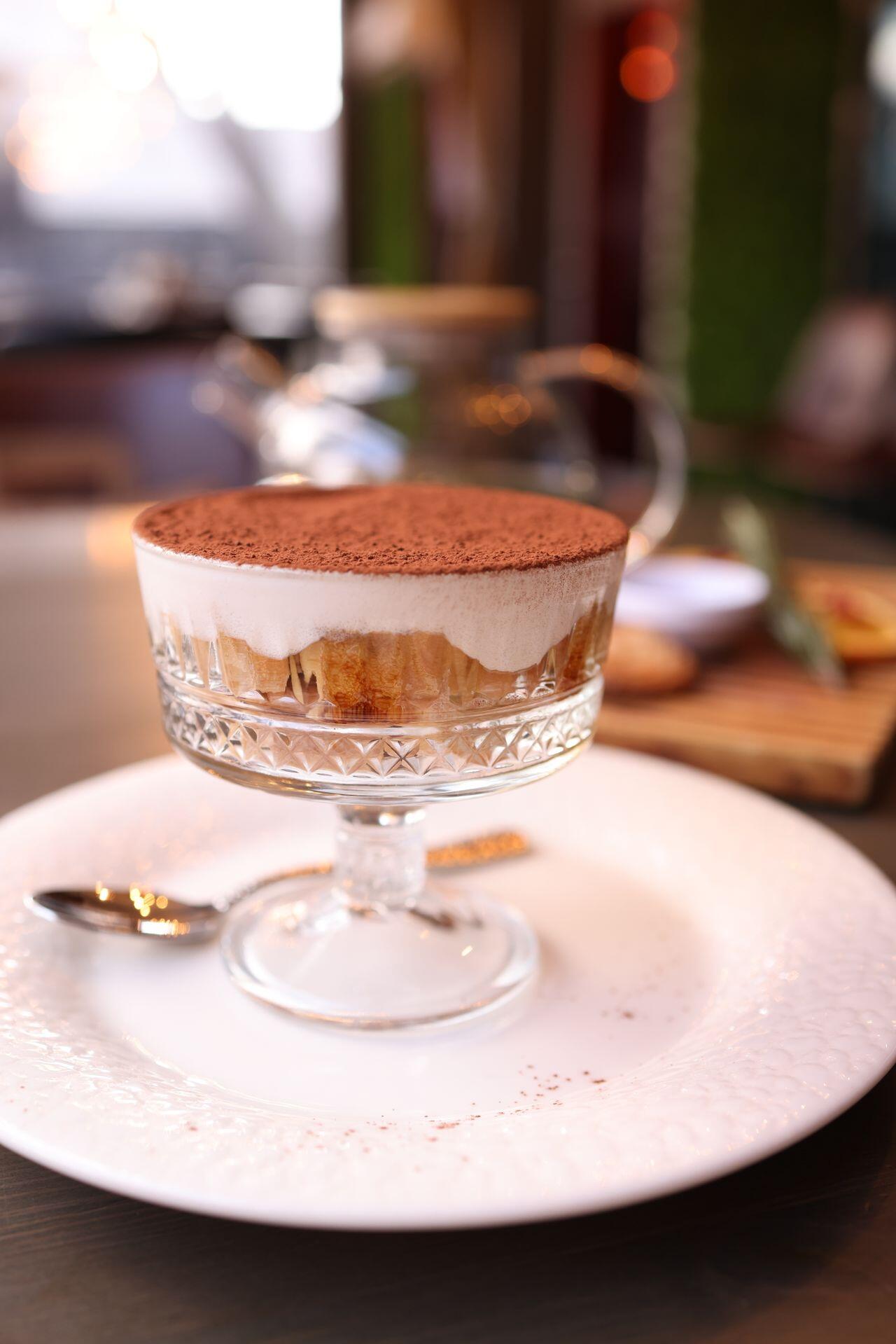 Tiramisu im Gals auf einem weißen Teller