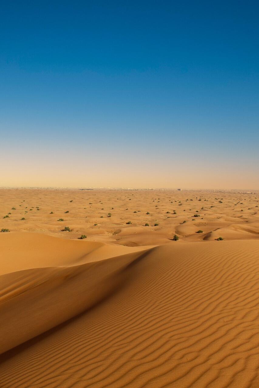 Große Sandfläche vor blauem Himmel