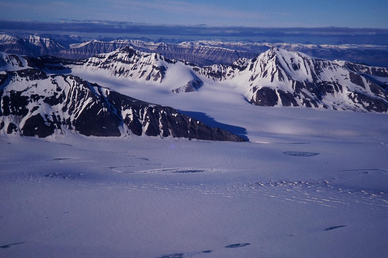 Schneeflächen und daraus herausragende Gebirge