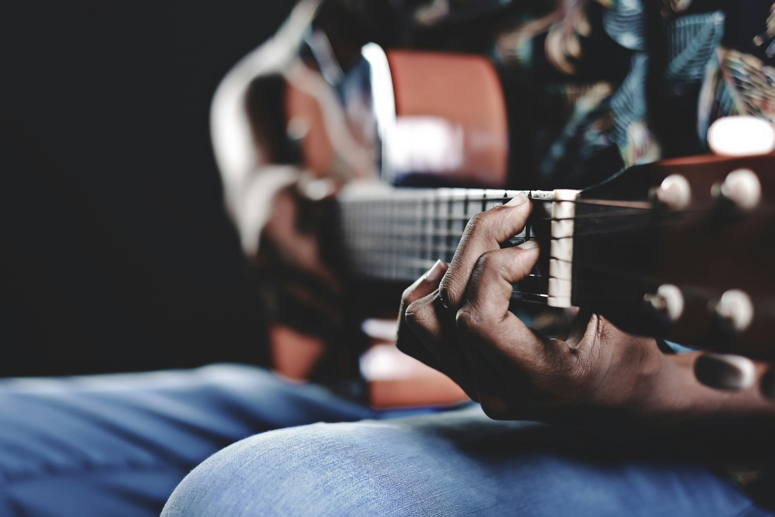Kvinde spiller guitar.