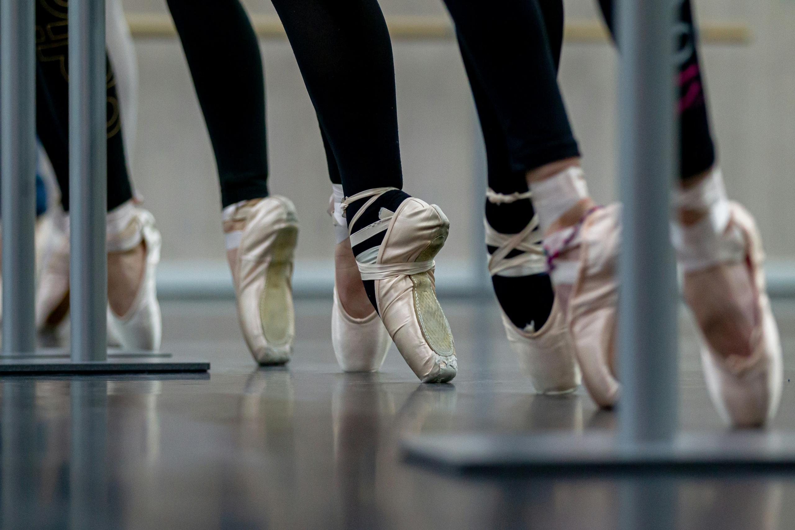 Balletdansere står på tæer.