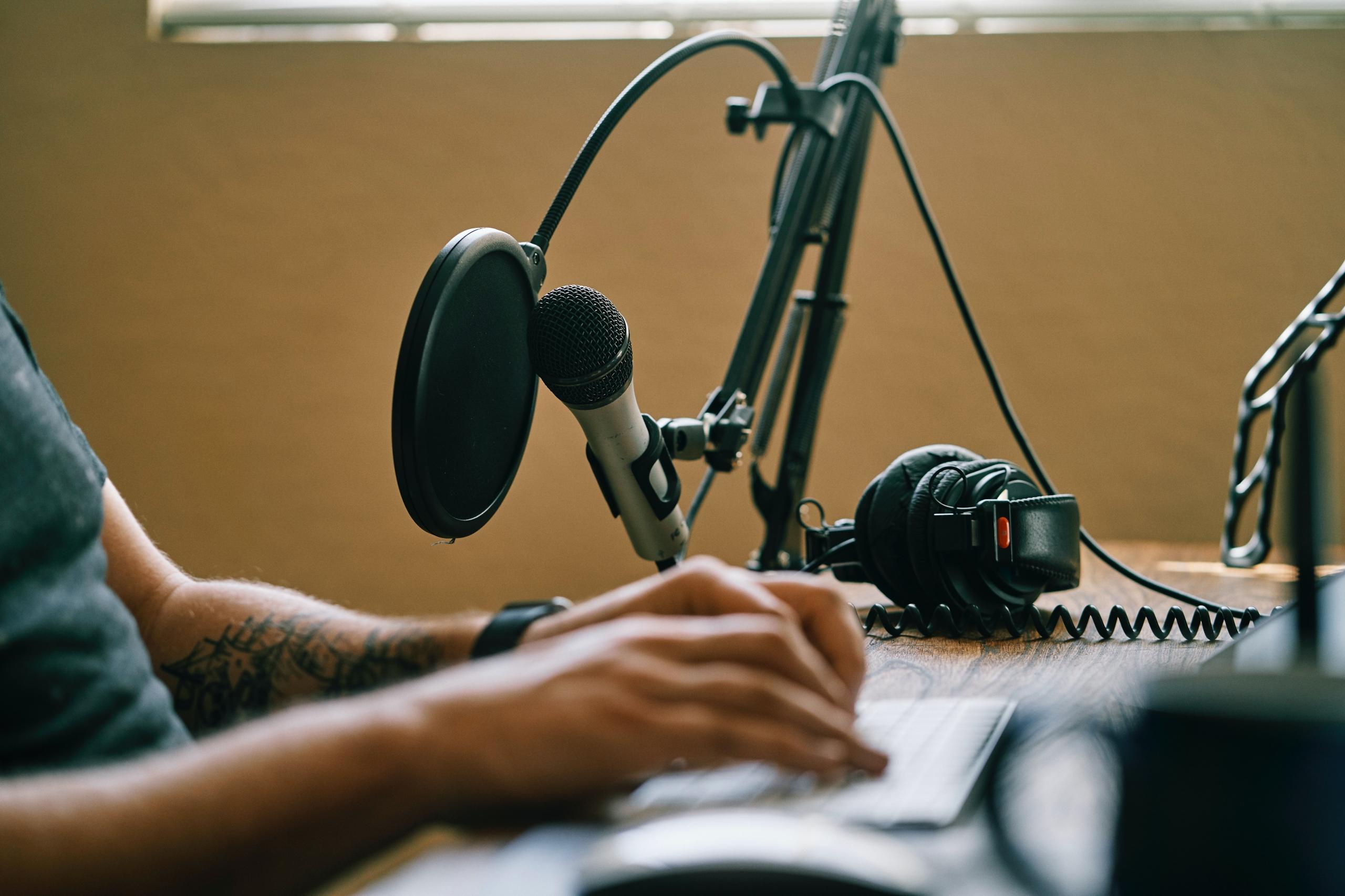 En mand sidder i sit studie og laver en lær italiensk podcast