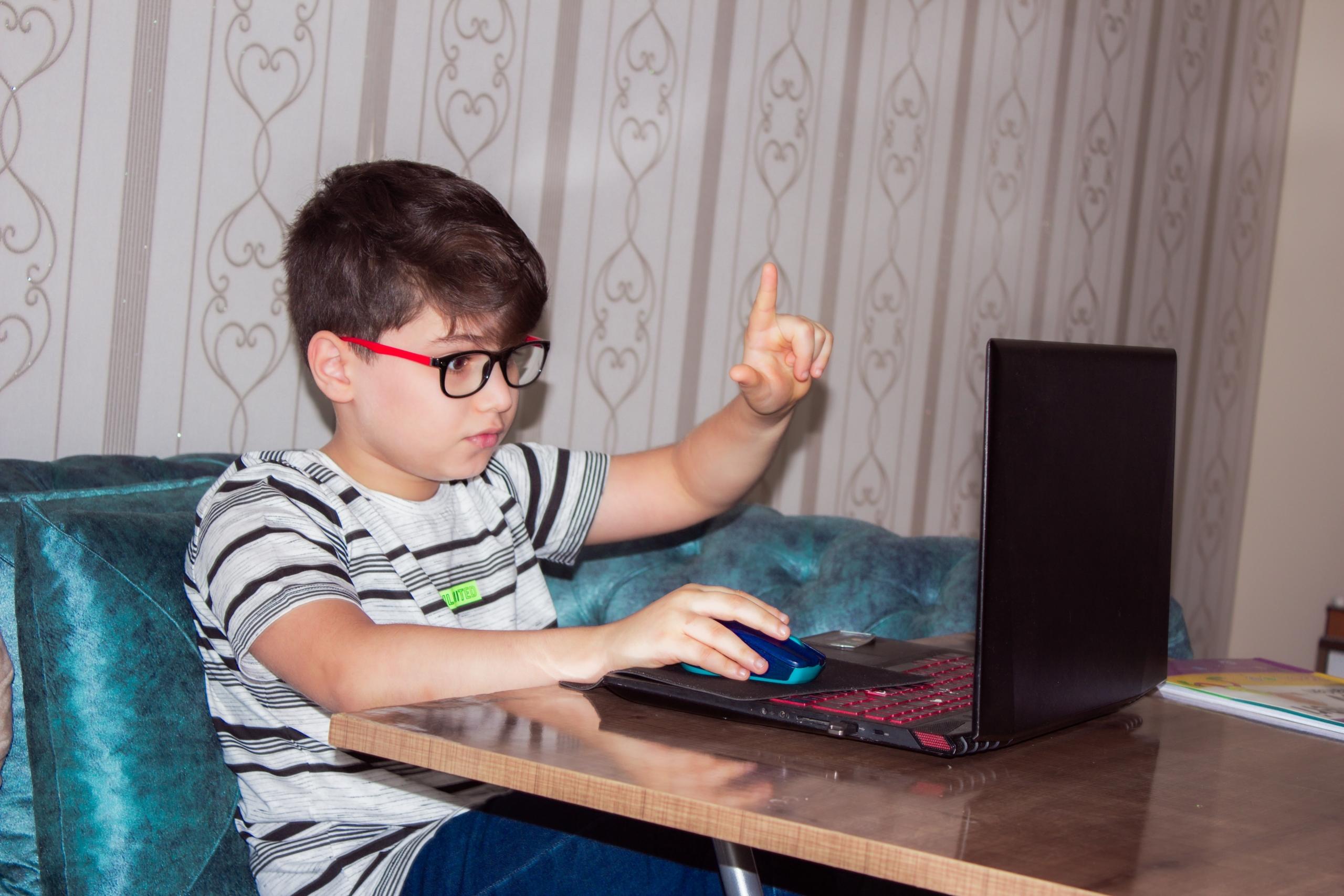 Dreng foran en computer, der får hjælp med lektier