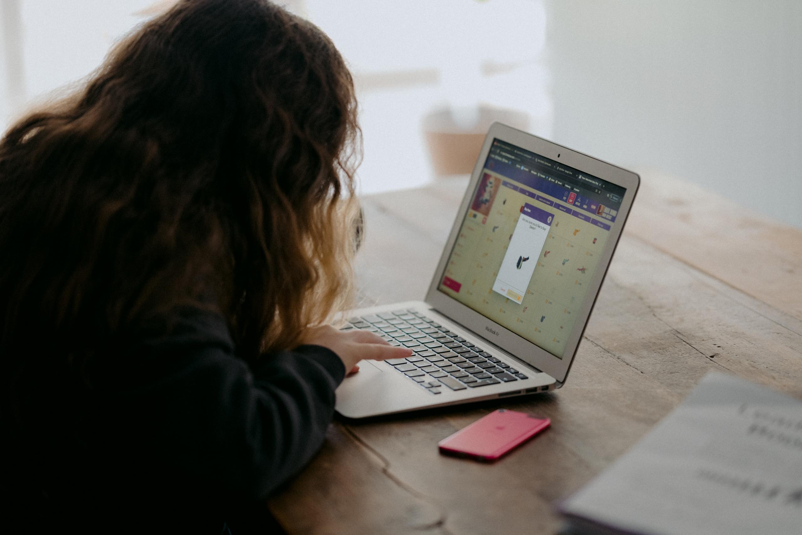 En pige får hjælp med lektier online ved sin computer