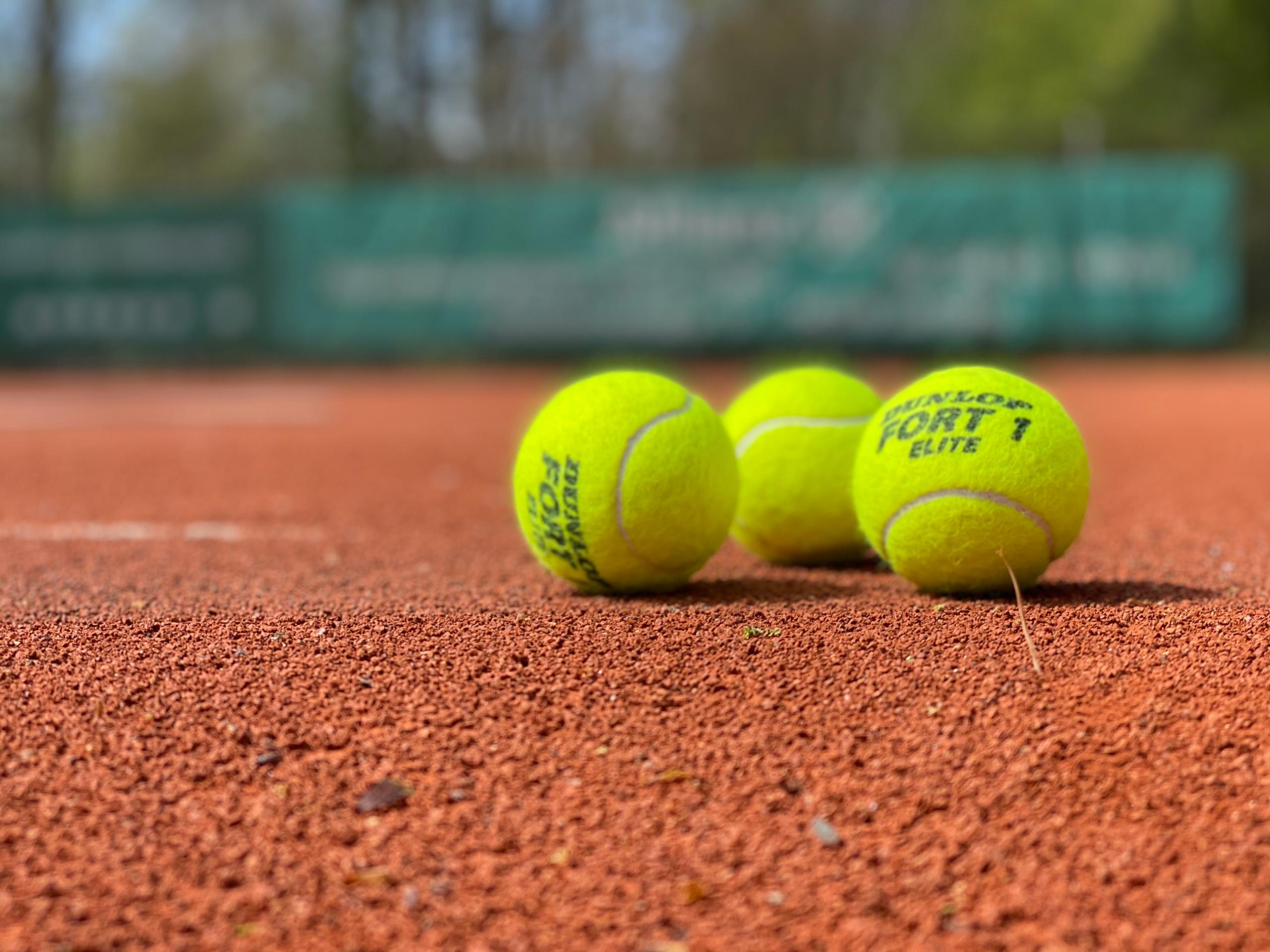 Gule tennisbolde på en tennisbane
