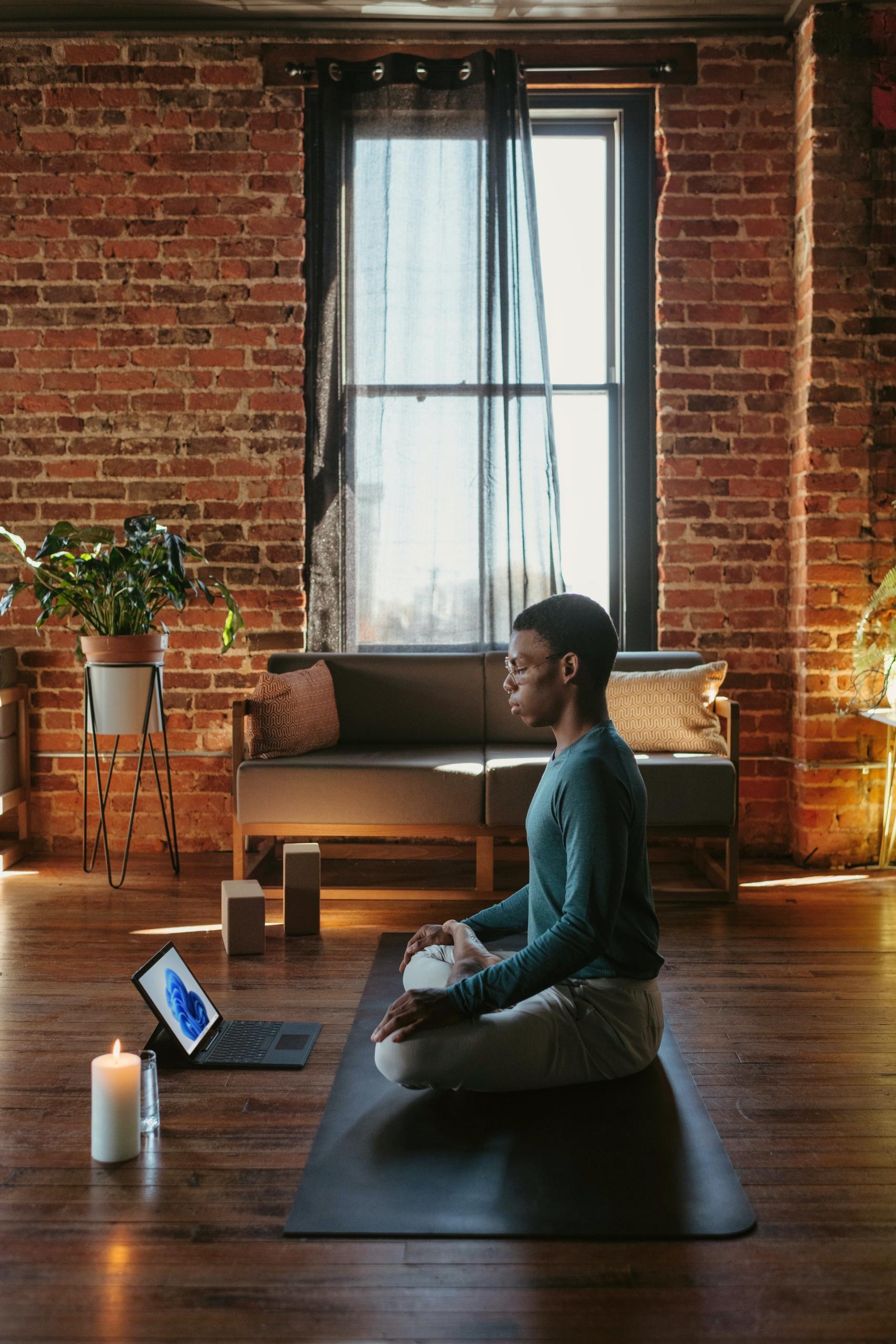 En mand sidder i et rum og laver yoga for mænd