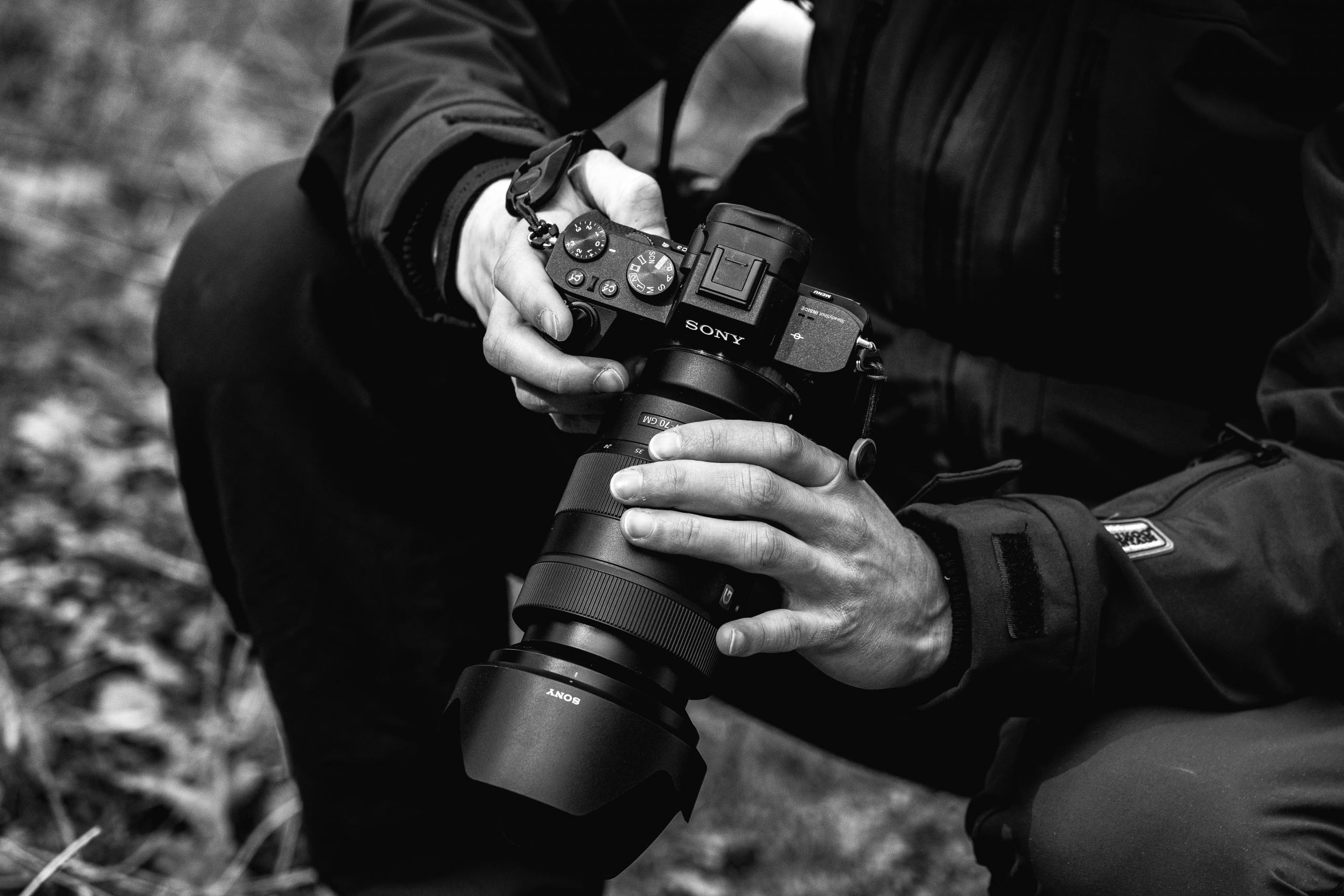 En fotograf med et kamera i sort hvid