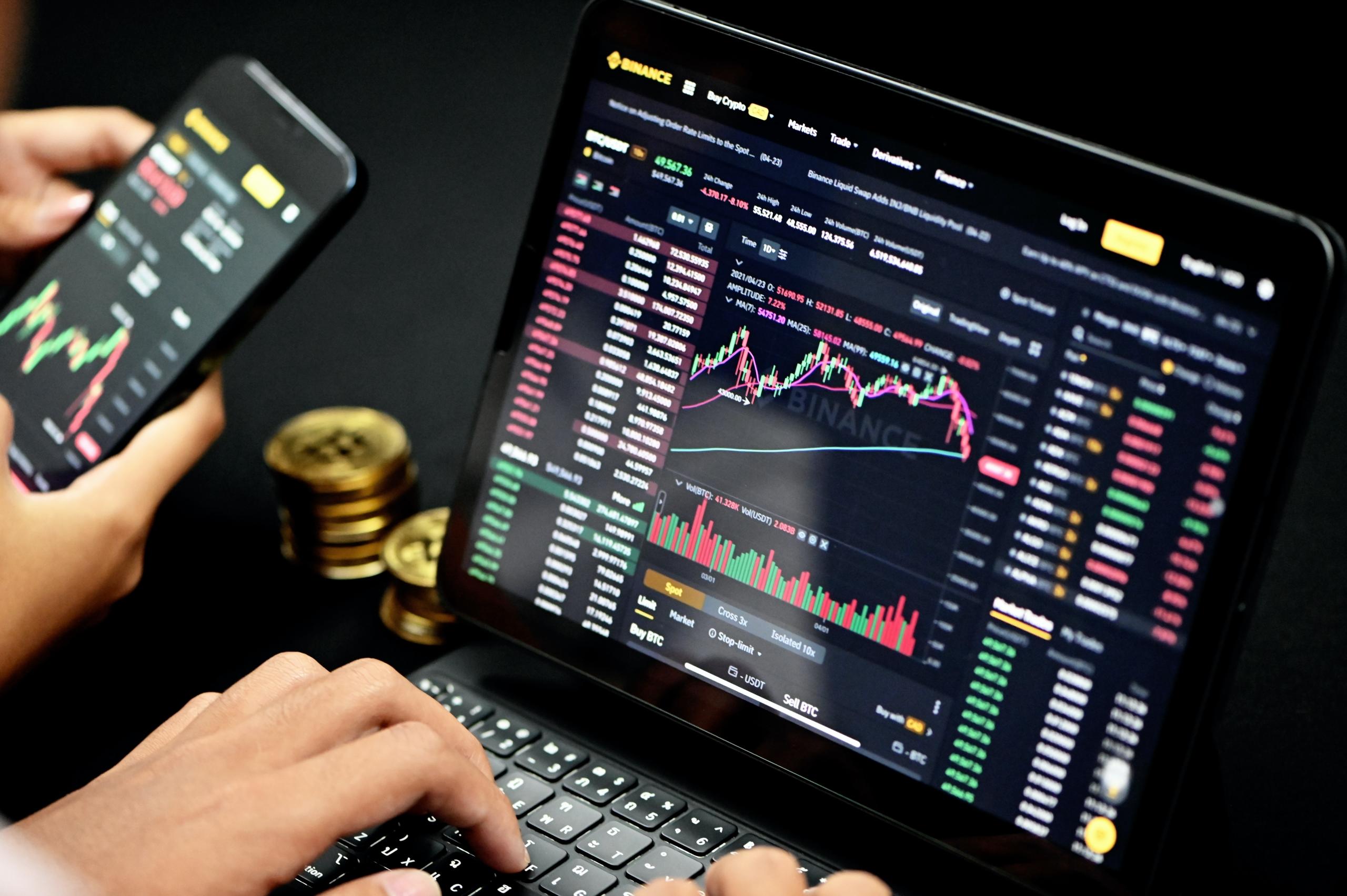 graf på telefon og computer over finansiering investering