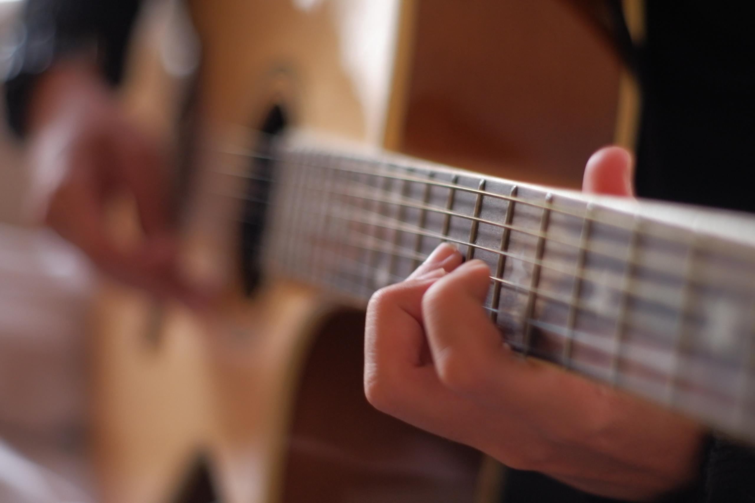 En piger med en guitar, der kender fordelene ved at spille guitar