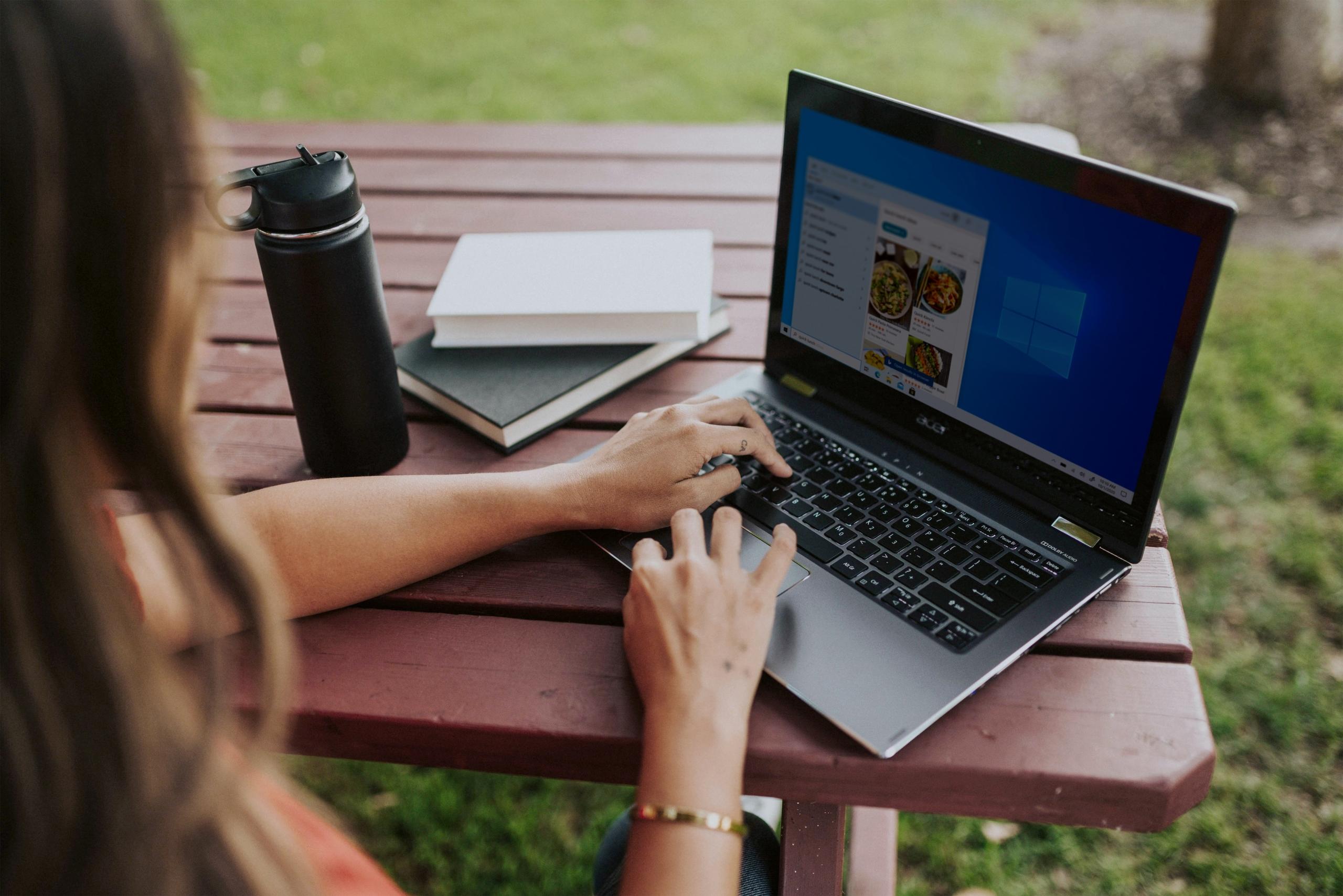 En kvinde sidder ved sin computer udenfor