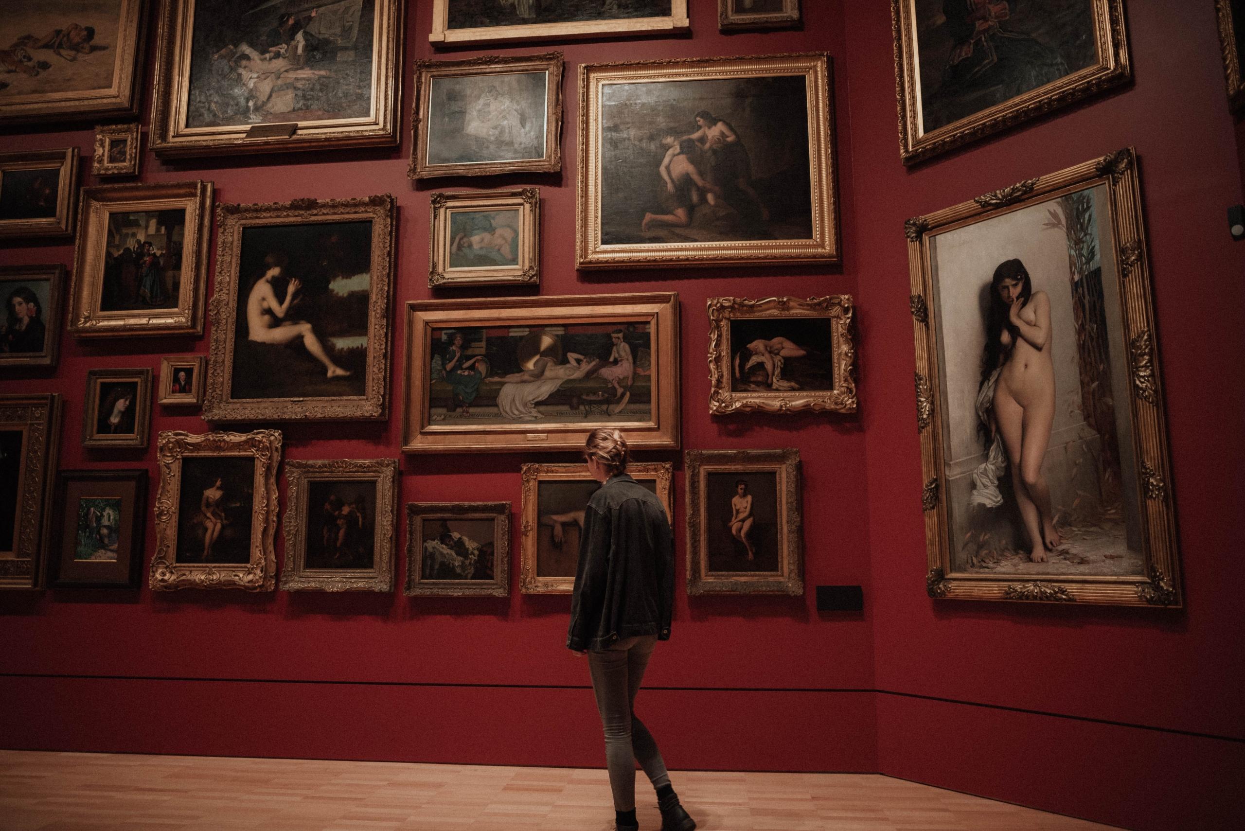 En museumsvæg med mange malerier