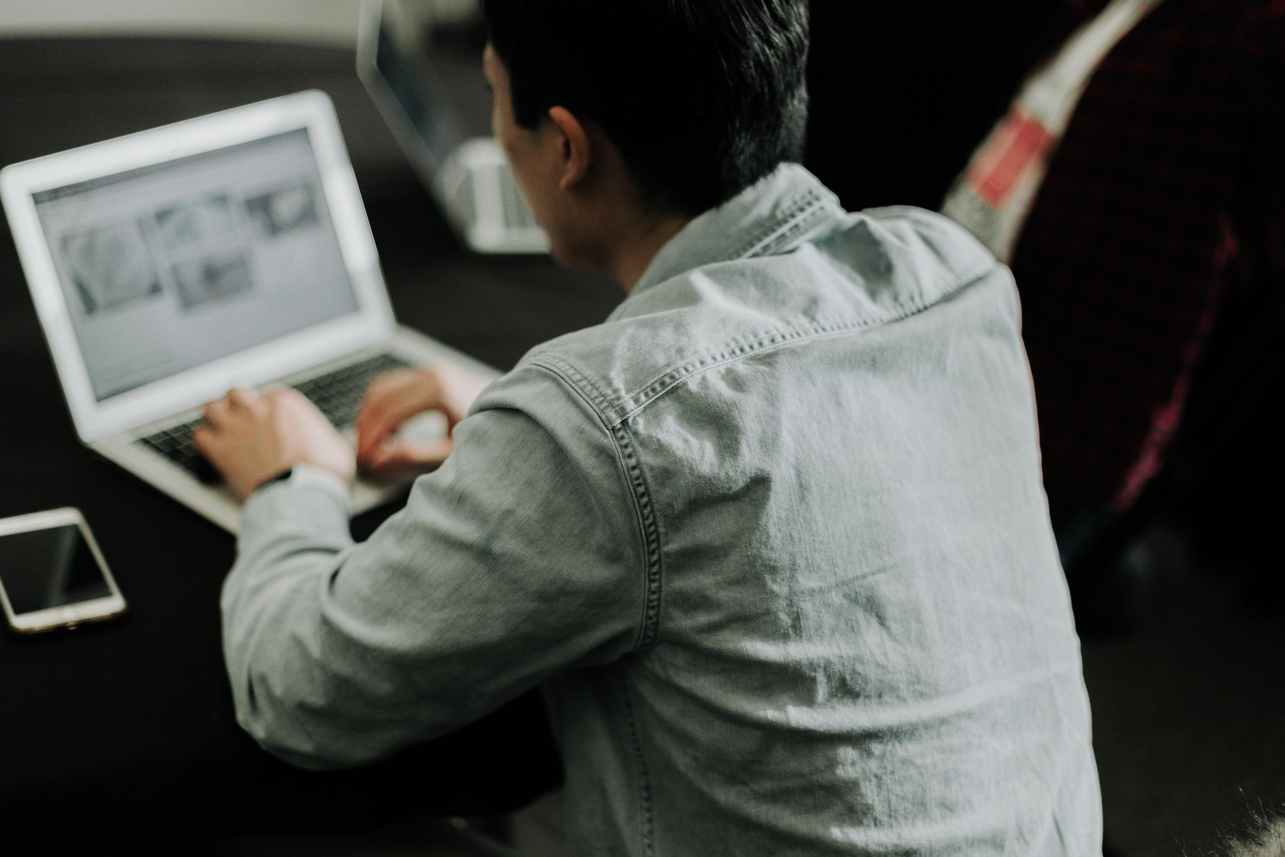 En mand skriver sit litteraturreview på sin computer