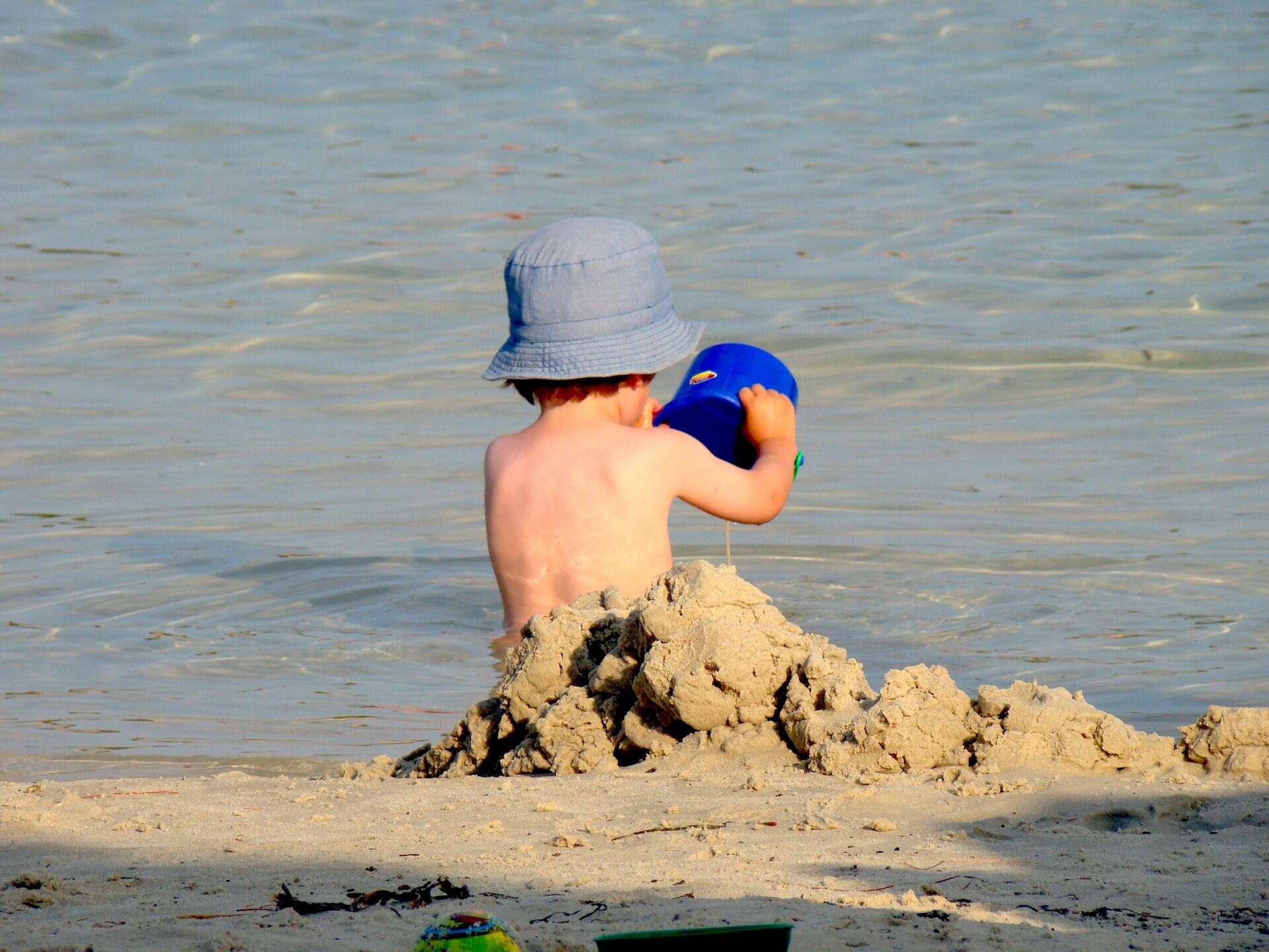 Dreng sidder på strand