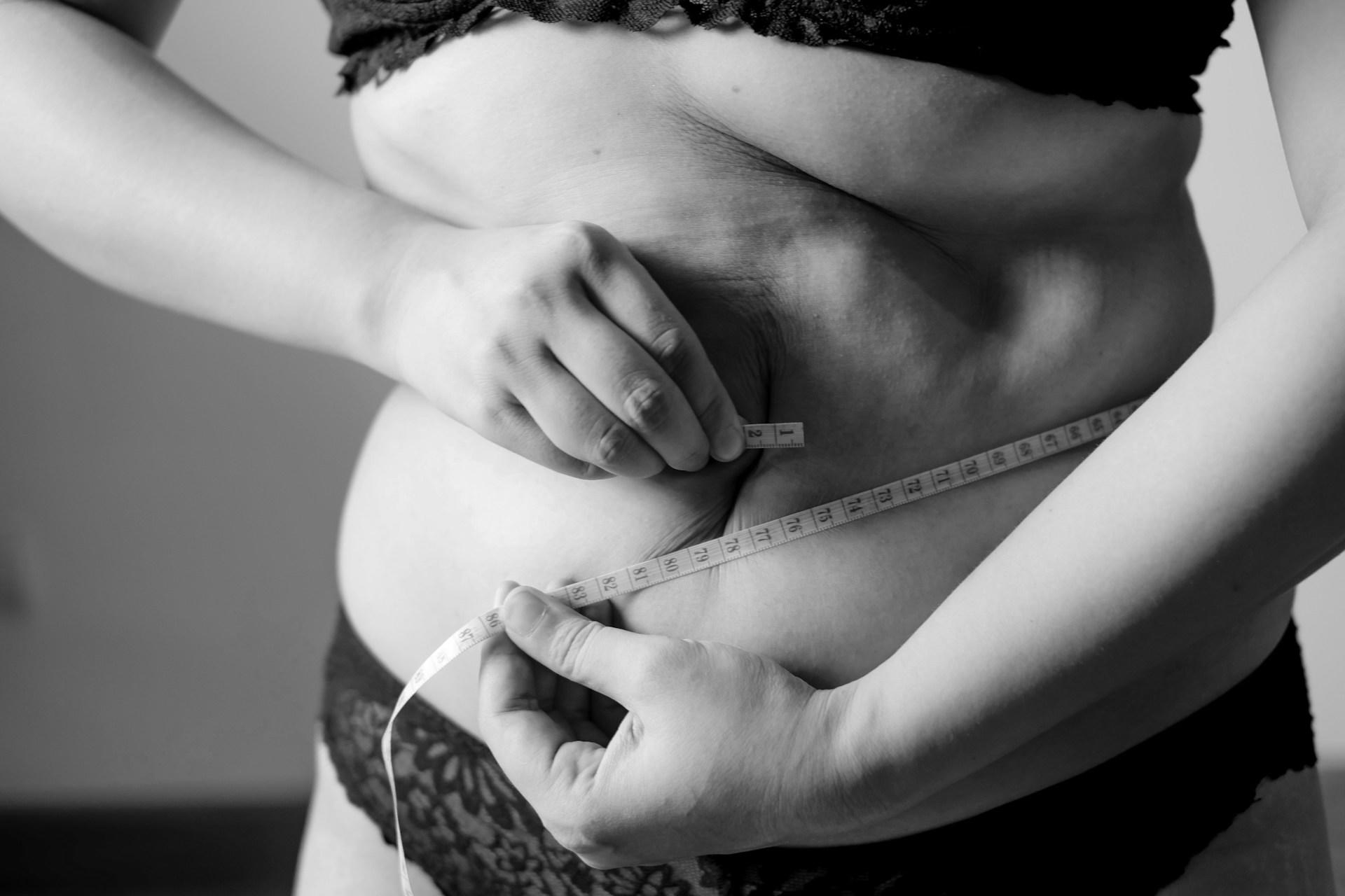 Frau mit Maßband um den Bauch