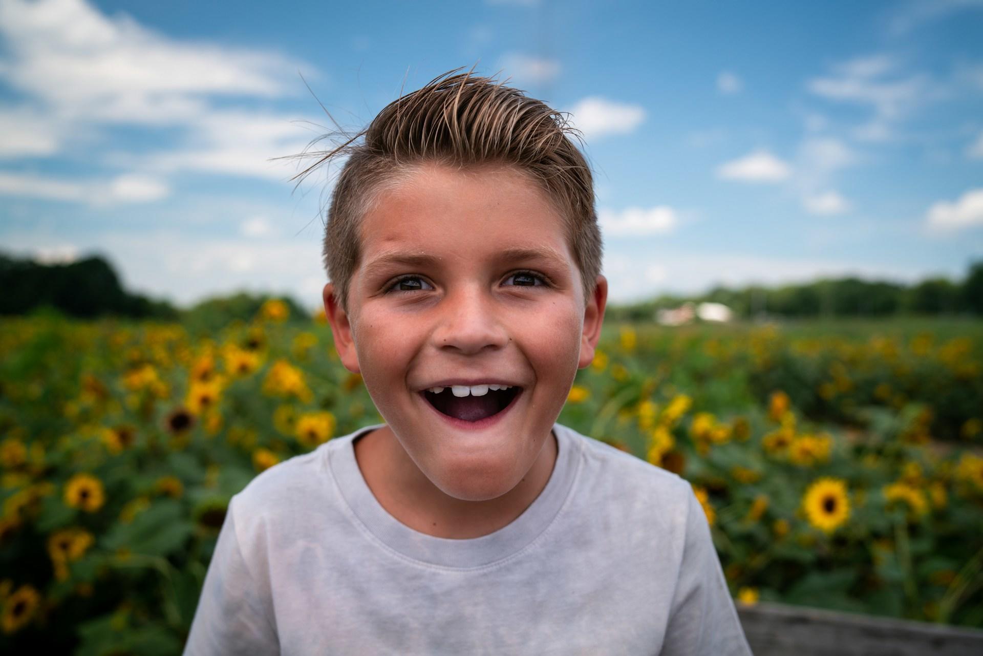 Fröhlicher Junge auf einem Sonnenblumenfeld